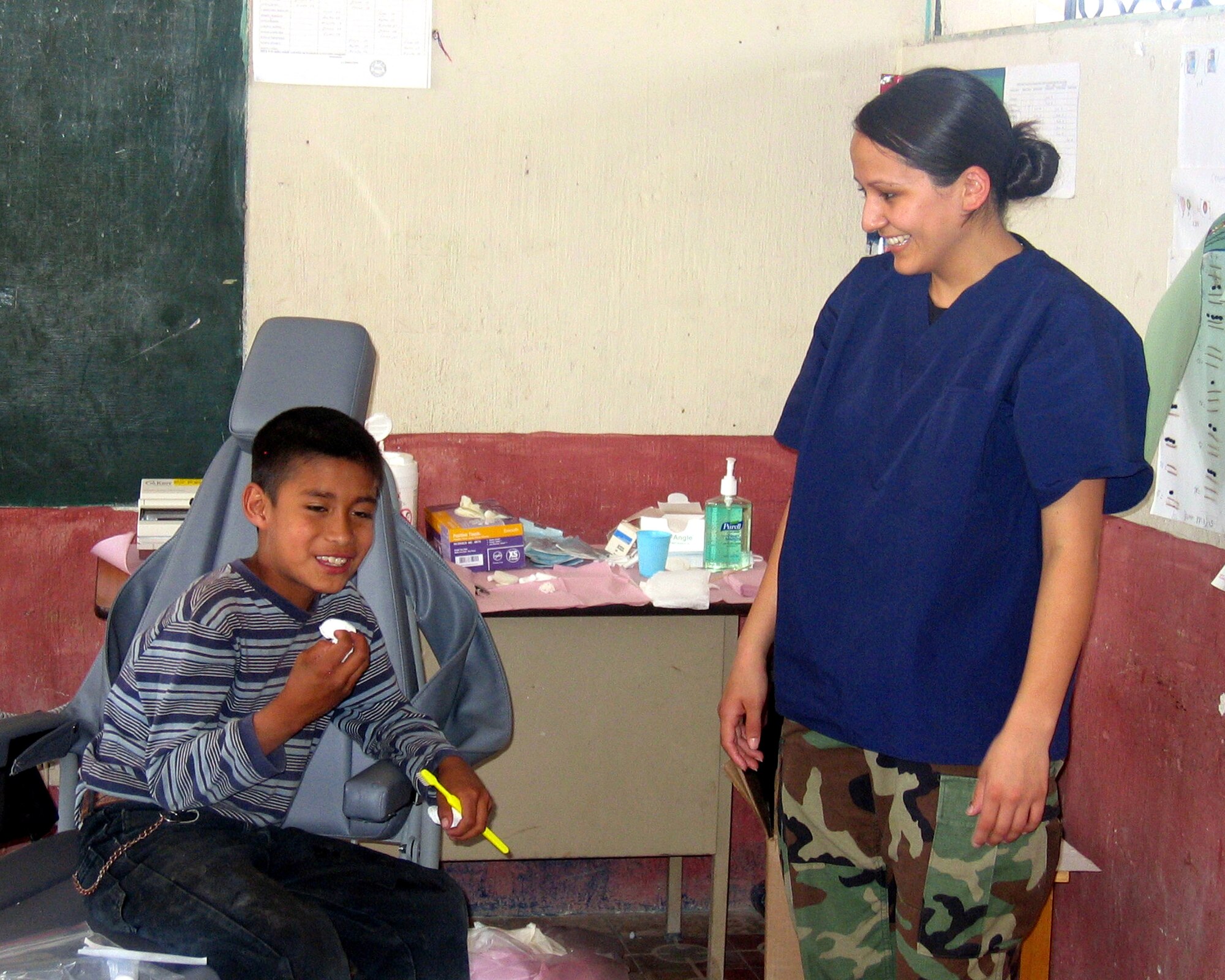 Airman 1st Class Laura Valenzuela De La Hoya, a dental technician from Vandenberg AFB, Calif., shares a laugh with a Guatemalan child after his dental visit. Airman Valenzuela De La Hoya assisted in extracting nearly 900 teeth and restoring another 85 during a 10-day humanitarian mission to various regions of Guatemala in April. (U.S. Air Force photo)