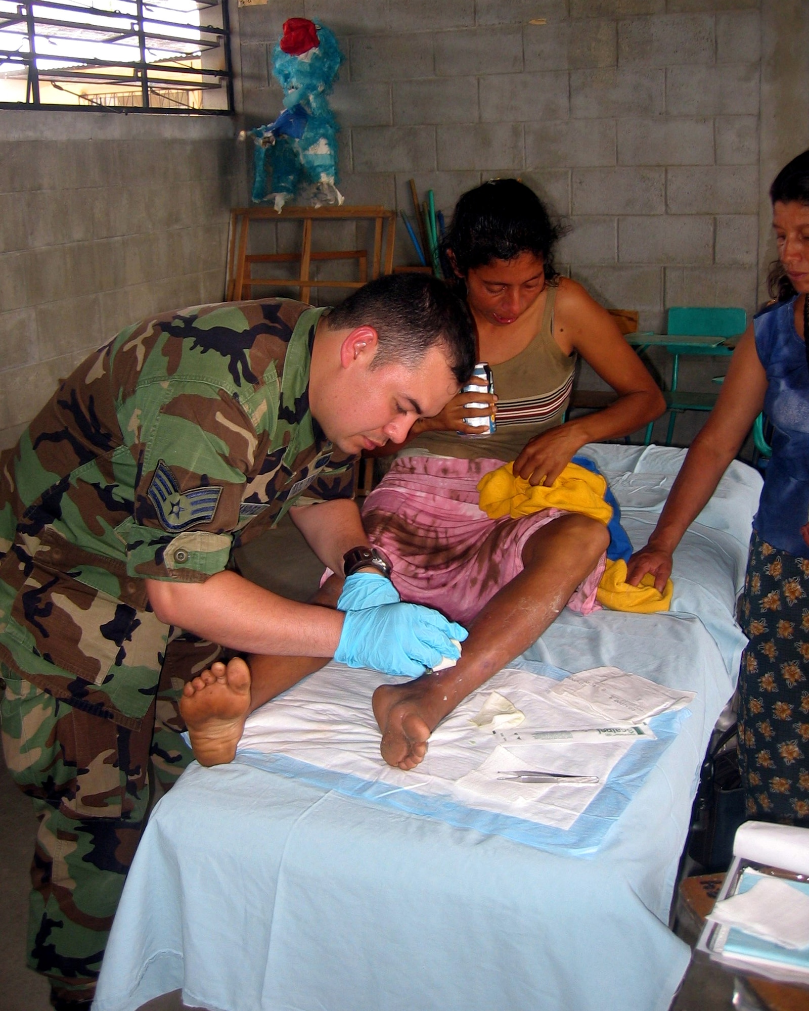 Staff Sgt. Oscar Hernandez, a public health technician, disinfects a woman's leg during a humanitarian mission in some of the poorest regions of Guatemala. In April, Sergeant Hernandez from Vandenberg Air Force Base, Calif., and another 12 Airmen from various Air Force Space Command bases, saw more than 8,000 patients in 10 days. (U.S. Air Force photo)
