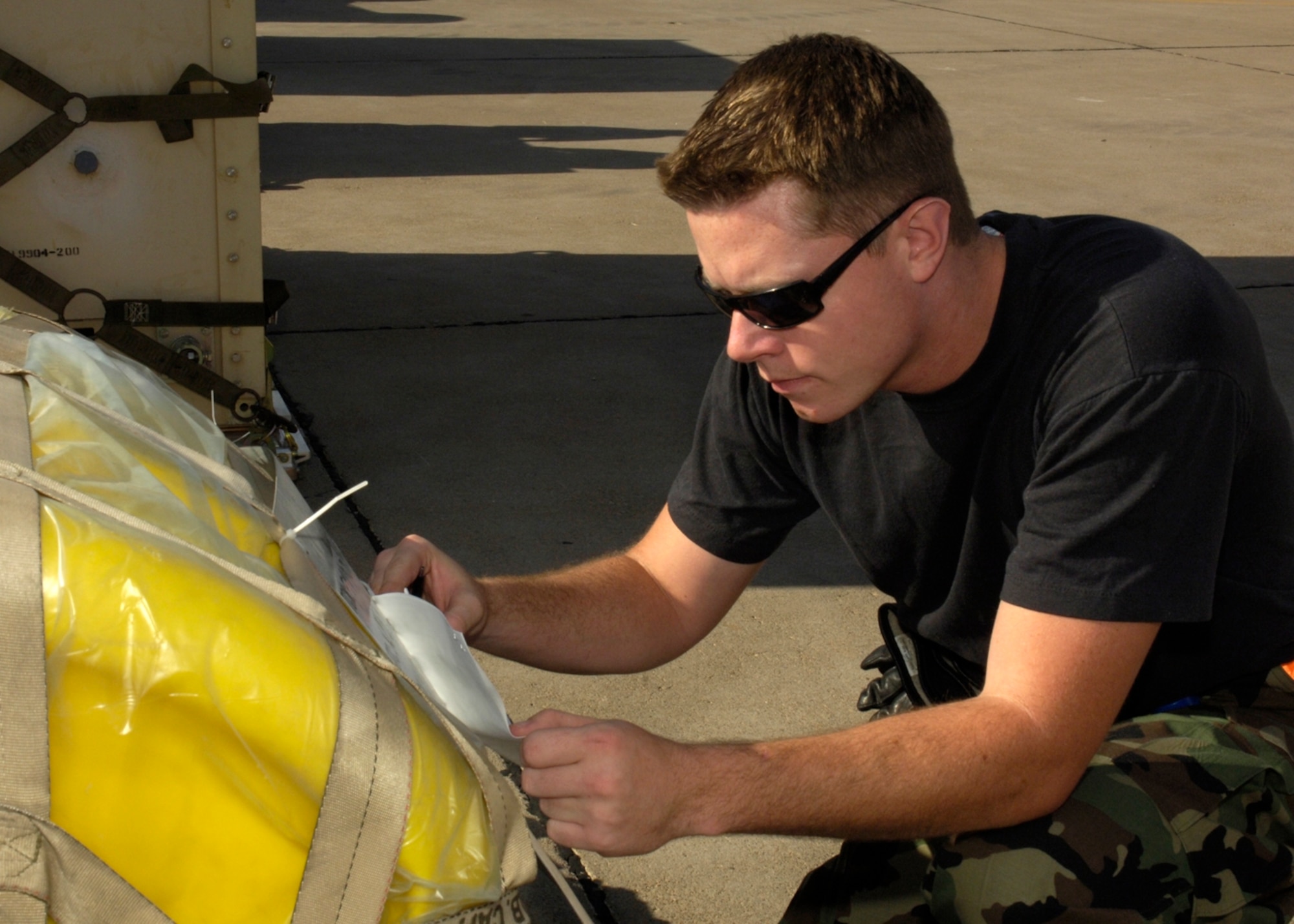 Senior Airman Andrew Broome, 49th Materiel Maintenance Squadron, checks cargo to ensure its air worthness in prepartion for the Coronet Gold Rush 07-02 exercise on at Holloman. Airman Broome was checking cargo as part of an exercise to help better prepare troops in the event of a deployment. (U.S. Air Force photo by Airman Michael Means)