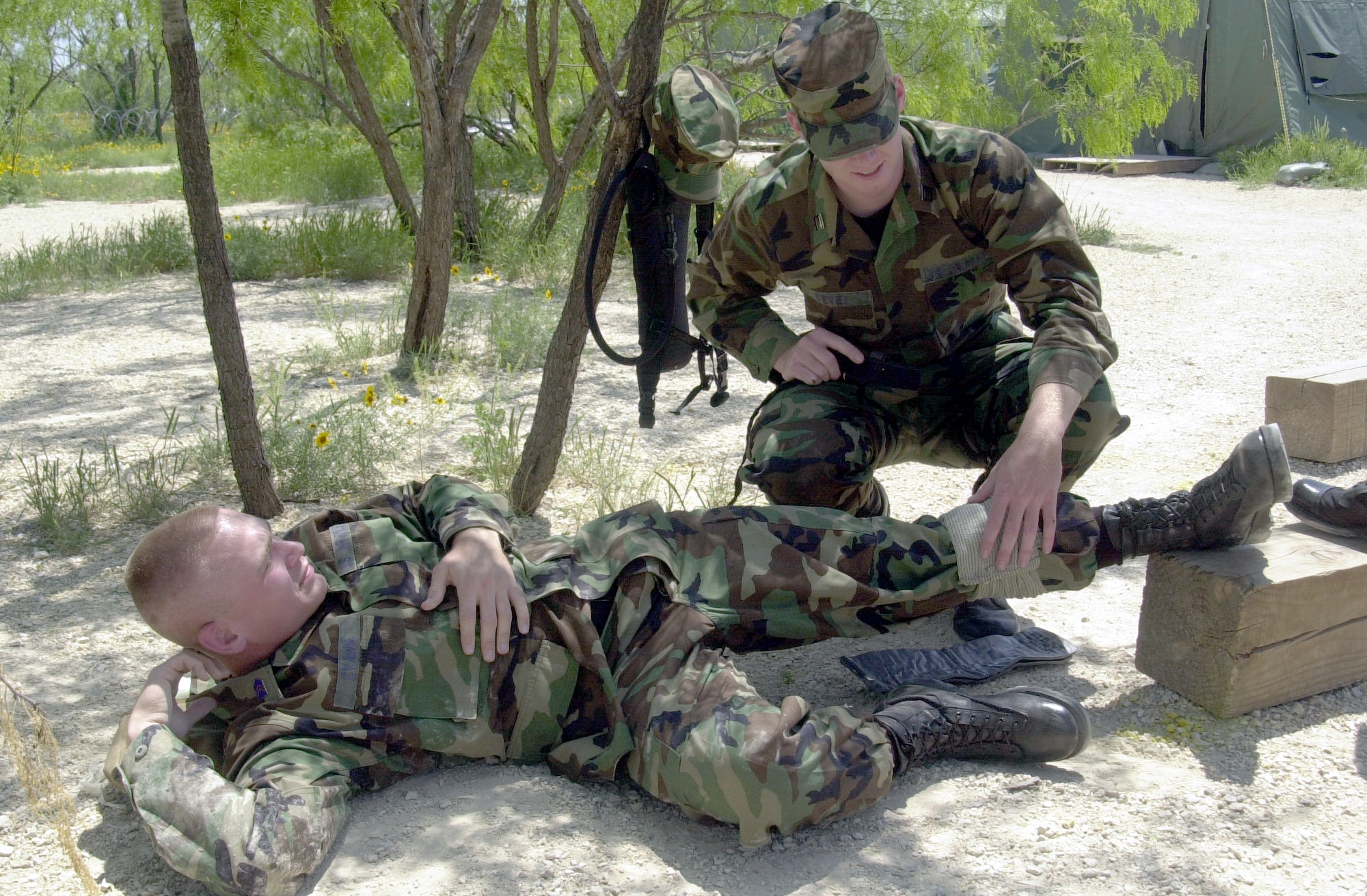 Air Force Reserve Officer Training Corps Cadet Matthew Sevey tends to a simulated wound on Cadet Brett Evans Jr.’s leg during the self-aid and buddy care portion of a field training exercise April 28 at Goodfellow Air Force Base’s Camp Sentinel exercise area. (U.S. Air Force photo by Airman 1st Class Stephen Musal)