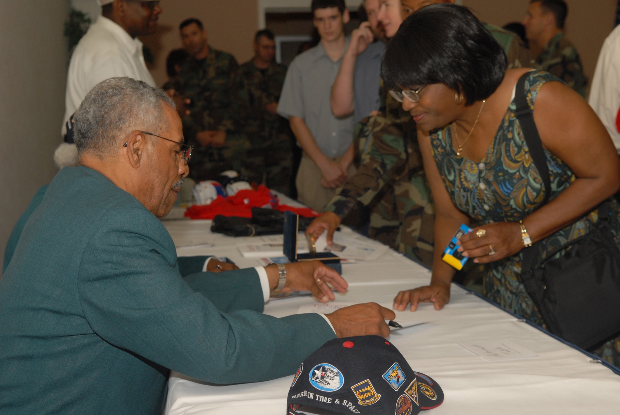 Donald Elder (left), a former member of the 99th Fighter Squadron and a member of the Dallas / Ft. Worth chapter of the Tuskegee Airmen, signs an autograph for Erma Brooks of the 17th Communications Squadron during a luncheon at the Goodfellow Events Center Thursday. For more information, see story below. (U.S. Air Force photo by Airman 1st Class Kamaile Chan)