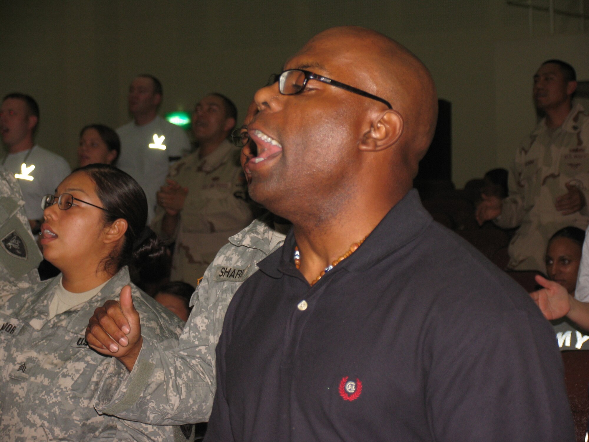 Chaplain (Capt) Anthony Cook, assigned to the Army Life Support Area Gospel Service, enjoys singing along with the rest of the crowd at the May 4th Gospel Festival at an undisclosed location in Southwest Asia.  Chap Cook accompanied his choir as they joined other choirs, soloists and performers.  The festival was sponsored by the 386 AEW Chapel. (AF/Photo Capt. Rickardo Bodden)