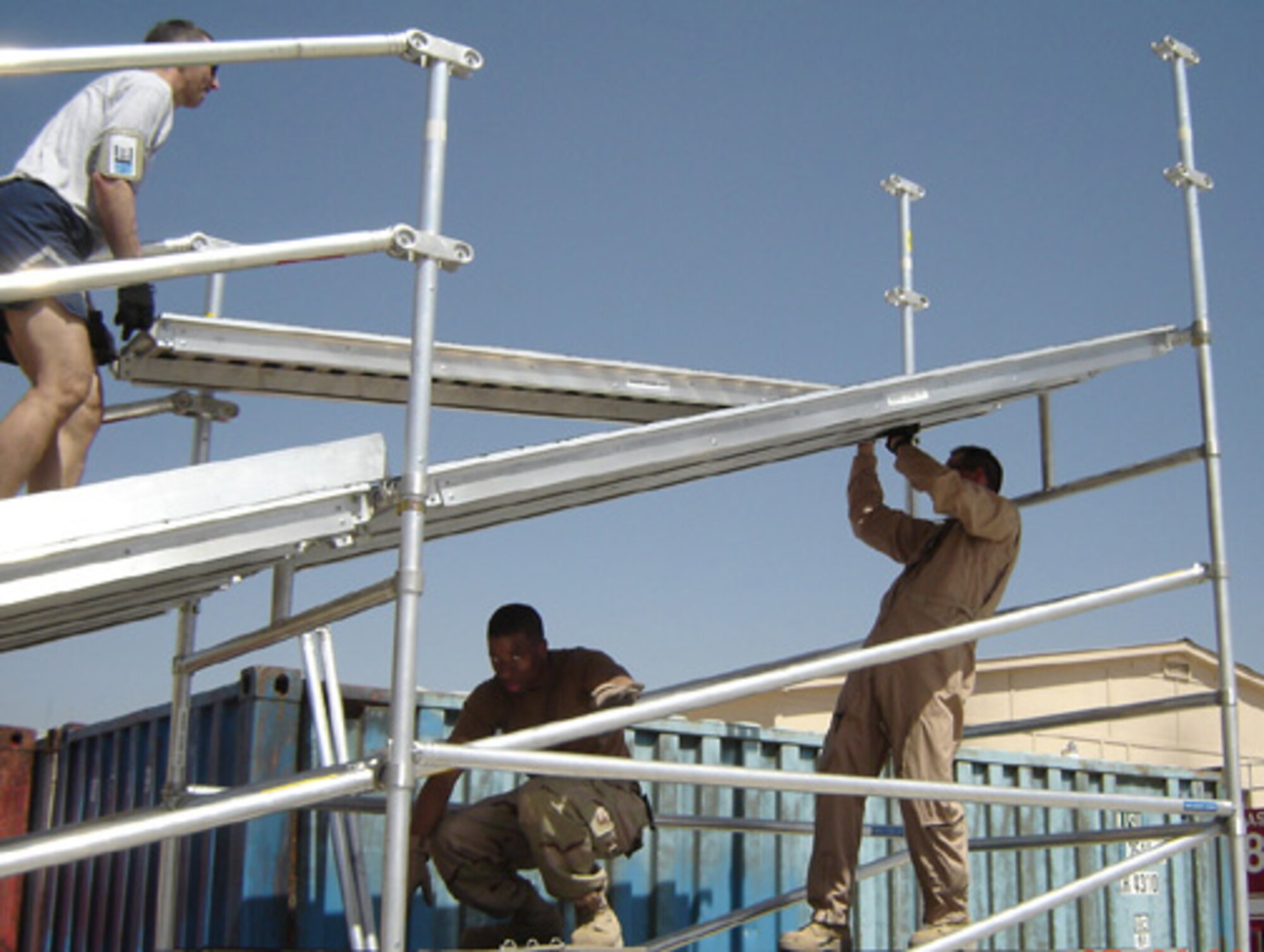 From left, Tech. Sgt. Andrew Baker, Senior Airman James Francois, and Tech. Sgt. Thomas Sullivan assemble a patient loading system April 28. The system will make Bagram's aeromedical evacuation operations safer and more efficient. (U.S. Air Force photo)