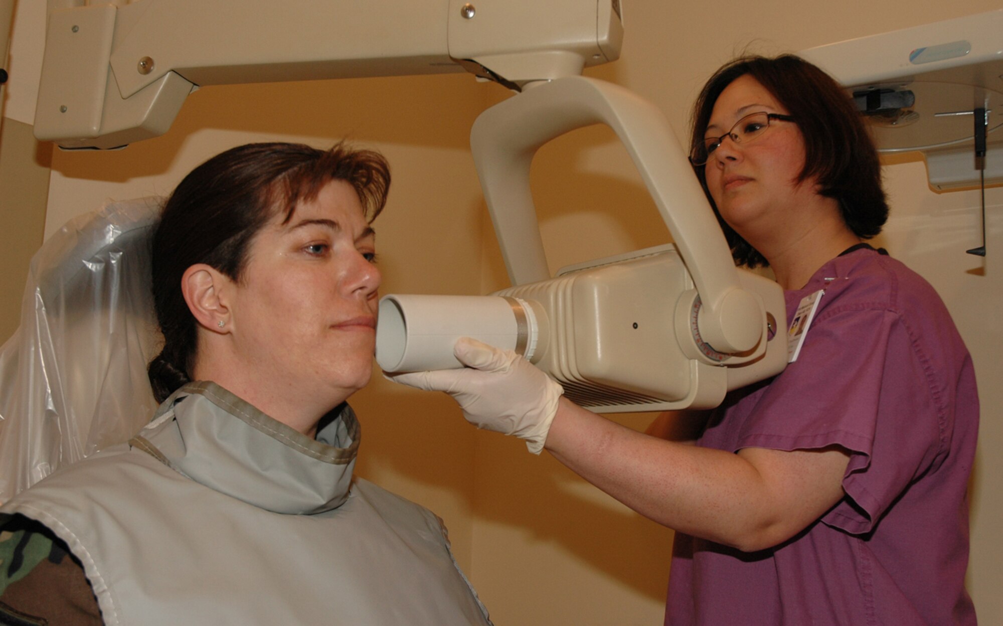 OSAN AIR BASE, Republic of Korea --  Staff Sgt. Chris Drennon, right, 51st Dental Squadron dental technician, prepares Master Sgt. Theresa Moran for an oral X-ray at the dental clinic here May 1. Technicians see about eight to nine patients per day, doing everything from X-rays to teeth cleanings. (U.S. Air Force photo by Staff Sgt. Benjamin Rojek)