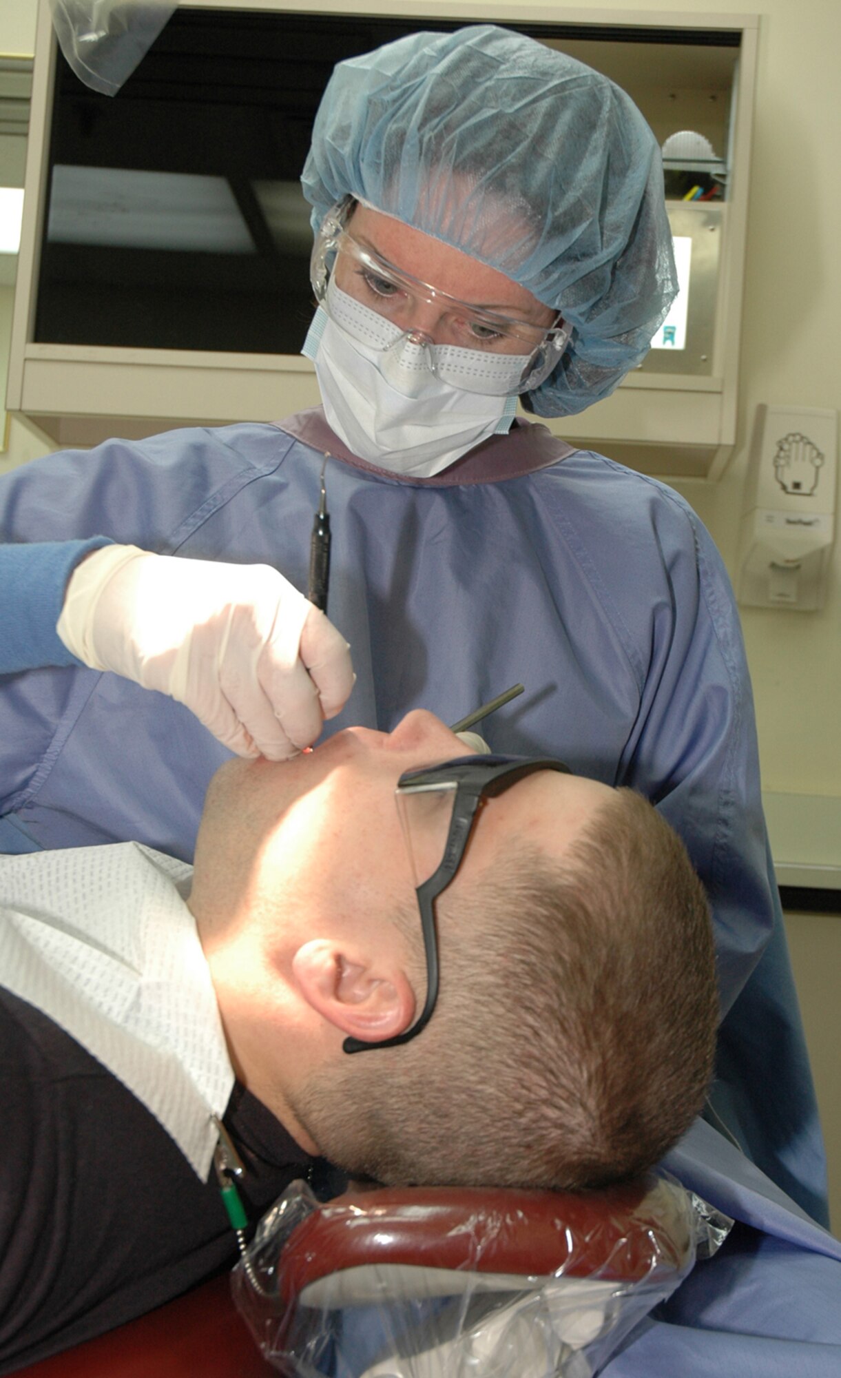 OSAN AIR BASE, Republic of Korea --  Staff Sgt. Miriam Larson, 51st Dental Squadron dental technician, conducts a teeth cleaning at the dental clinic here May 1. Dental technicians do more than teeth cleanings - they are also trained in areas such as oral X-rays, instrument sterilzation, and records and reception. (U.S. Air Force photo by Staff Sgt. Benjamin Rojek)