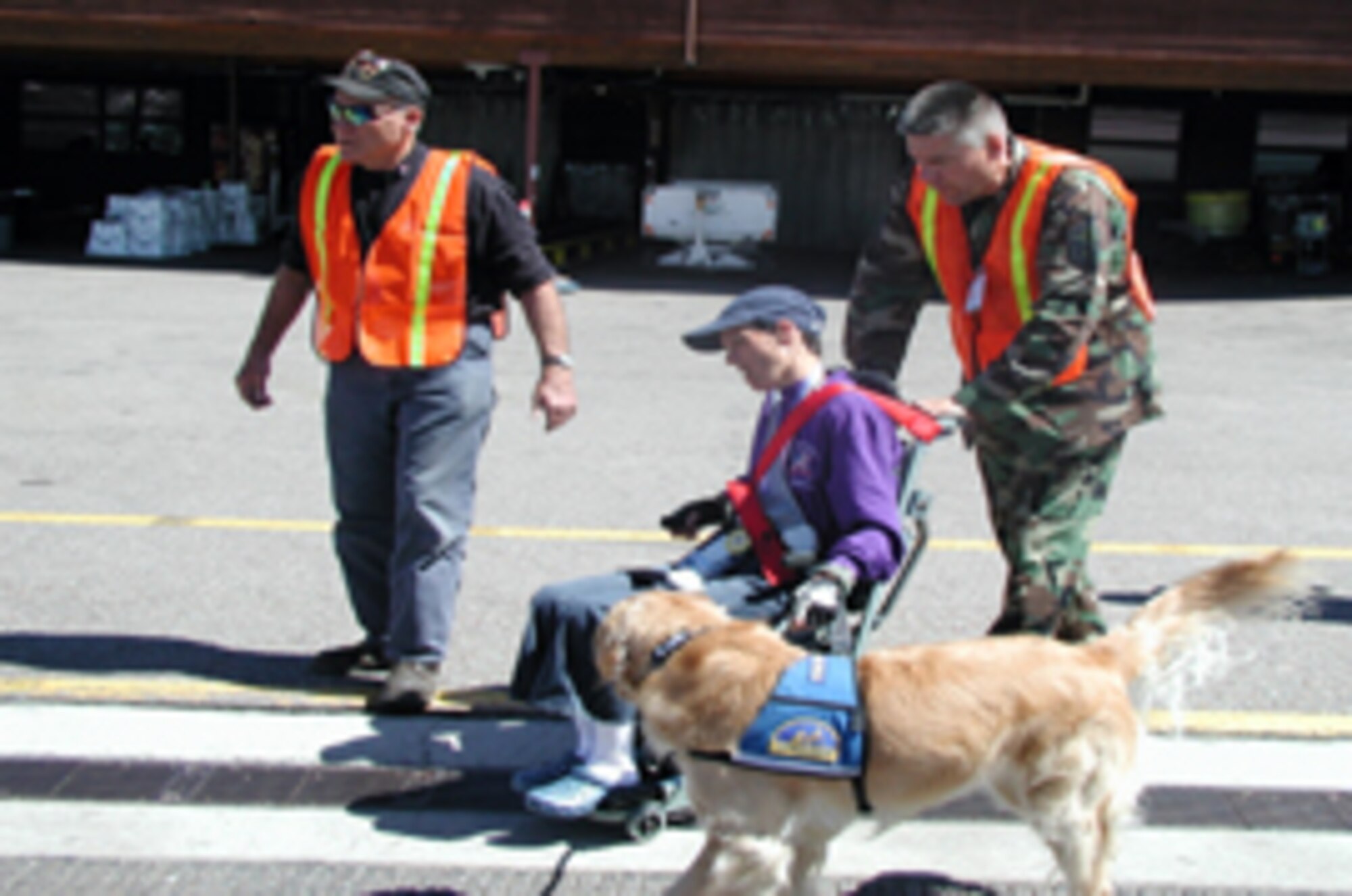 Jay Parker, Veterans Affairs athletic volunteer, guides Master Sgt. Randell Voy, 308th Aircraft Maintenance Unit Weapons Flight chief, Buddy Hayes and her service dog, Ellie, to a bus waiting to take them to Snowmass Village, Colo., March 31. Six Airmen from Luke volunteered to help at the 21st National Disabled Veterans Winter Sports Clinic. The clinic promotes rehabilitation by instructing veterans with disabilities in adaptive Alpine and Nordic skiing and introducing them to a number of other adaptive recreational activities and sports. (Photo by Staff Sgt. Phillip Butterfield)
