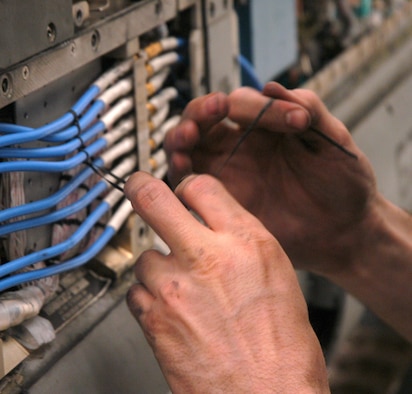 KUNSAN AIR BASE, Republic of Korea  May 7, 2007 -- Senior Airman Chad Engelman, 8th MXS electronic warfare systems journeyman, ties down electrical components in an electronic countermeasure pod May 7. Maintainers tie down the components during flight so as pilots pull high-G maneuvers, the components aren't rattled out of place. (U.S. Air Force photo/Senior Airman Stephen Collier)