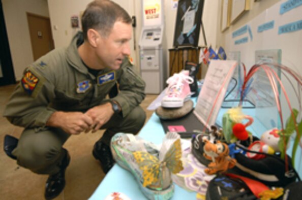 Col. David Orr, 56th Fighter Wing vice commander, judges the Sexual Assault Awareness Month Stand In Their Shoes contest. The winner of the individual contest, Jeanne Schmidt, 56th Mission Support Squadron, submitted a “Victim No More” hot pink high top. The group winner was the First Sergeants Council. (Master Sgt. William Gomez)
