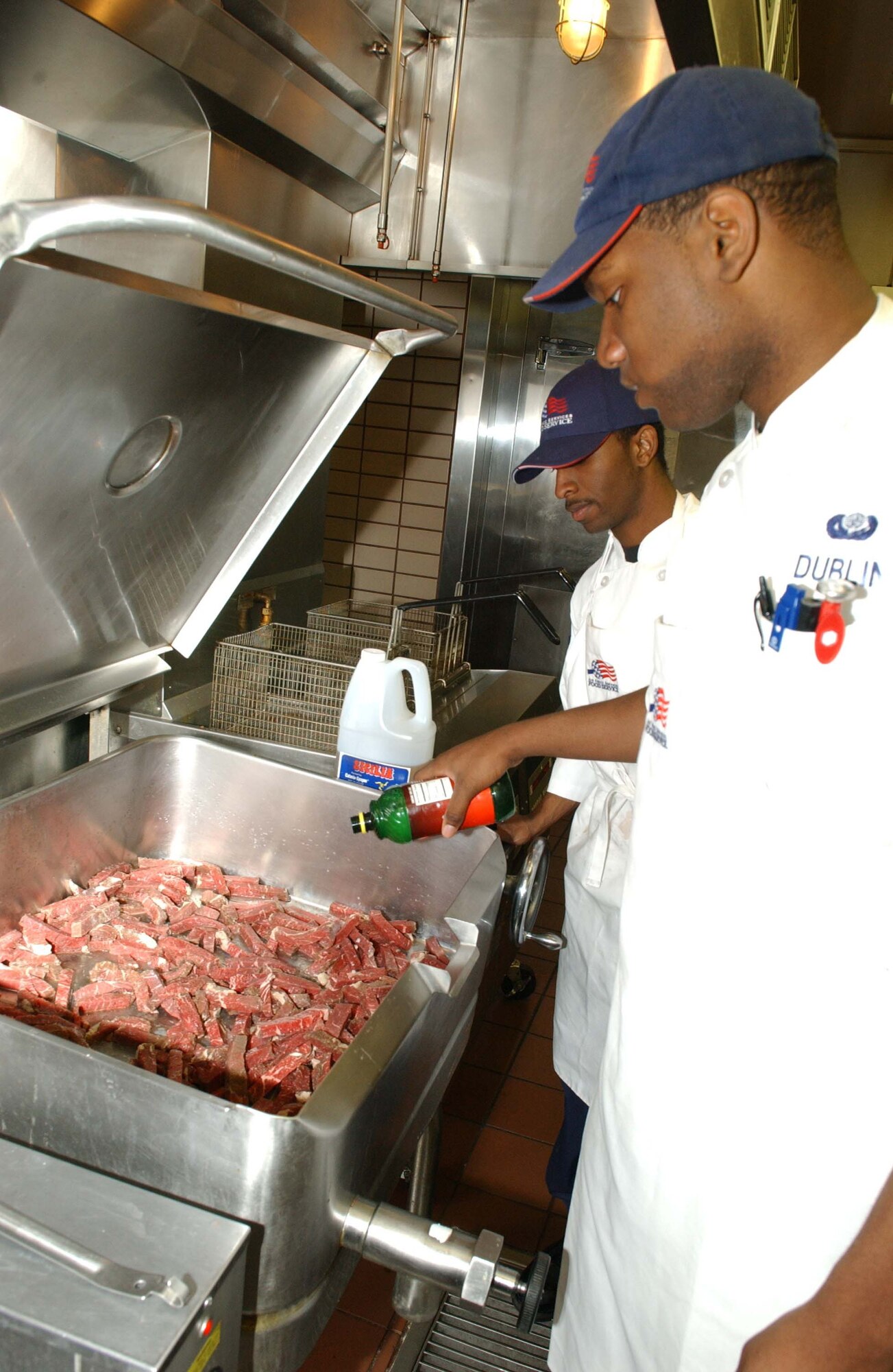 EIELSON AIR FORCE BASE, Alaska -- Senior Airman Vincent Dublin, Airman David Whitehead, 354th Force Support Squadron, prepares sixty servings of beef steak on May 03. At any one given time there are nine cooks that can be found preparing meals for Airmen of Eielson starting as early as 4:30 in the morning and ending at 6:00 in the evening.  (U.S. Air Force photo by Airman 1st Class Christopher Griffin)