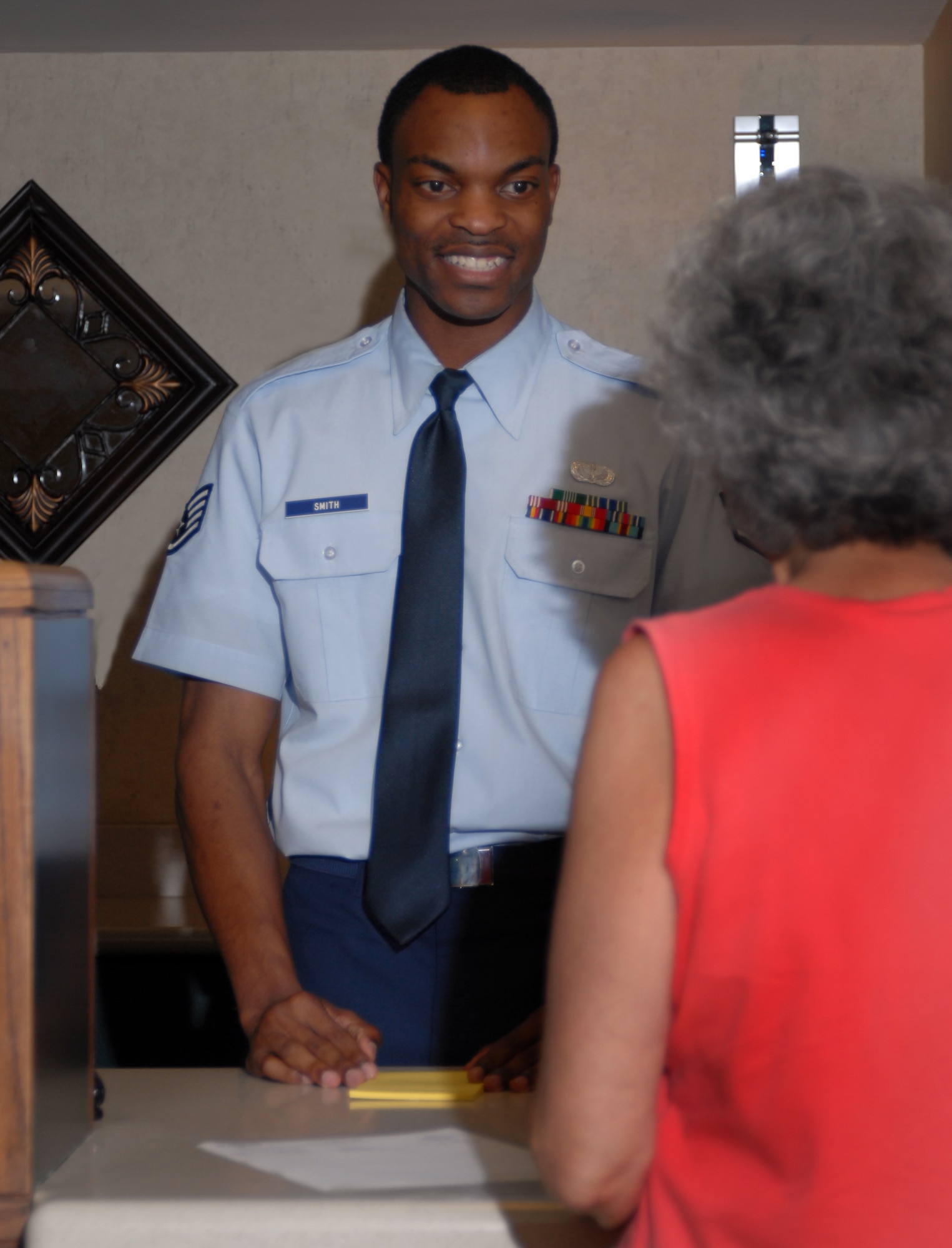 Staff Sgt. Richard Smith, 314th Service Squadron, helps guest Karen Metcalf check out of the Razorback Inn. The Razorback Inn won the 2006 AETC Excellence Award this past year. (USAF photo by A1C Steele Britton)