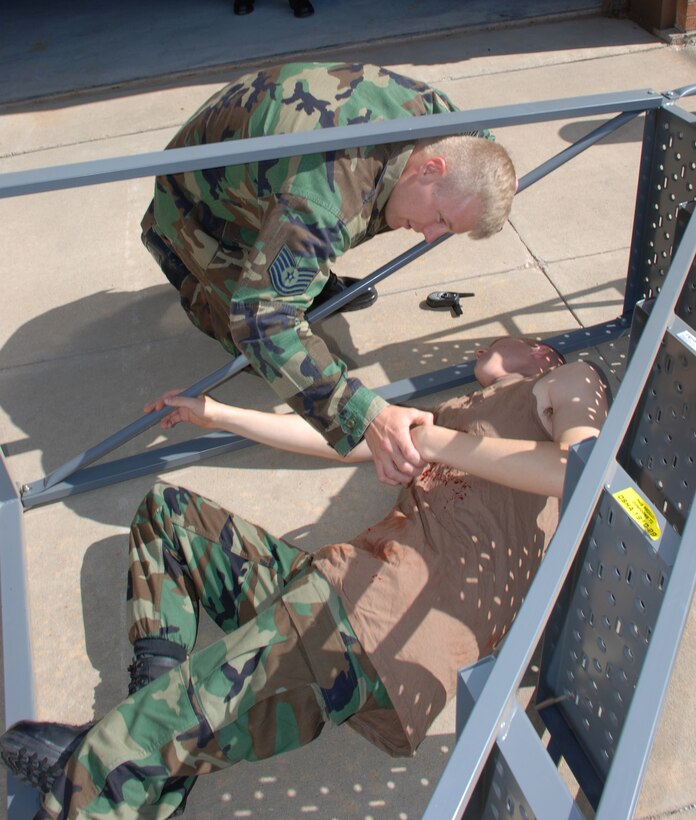 Tech. Sgt. Robert Rogers, an instructor with the 363rd Training Squadron, inspects the "wounds" of an Airman-in-Training prior to performing self-aid buddy care, during the Severe Weather Response Excercise May 3. (U.S. Air Force photo/Airman 1st Class Jacob Corbin)
