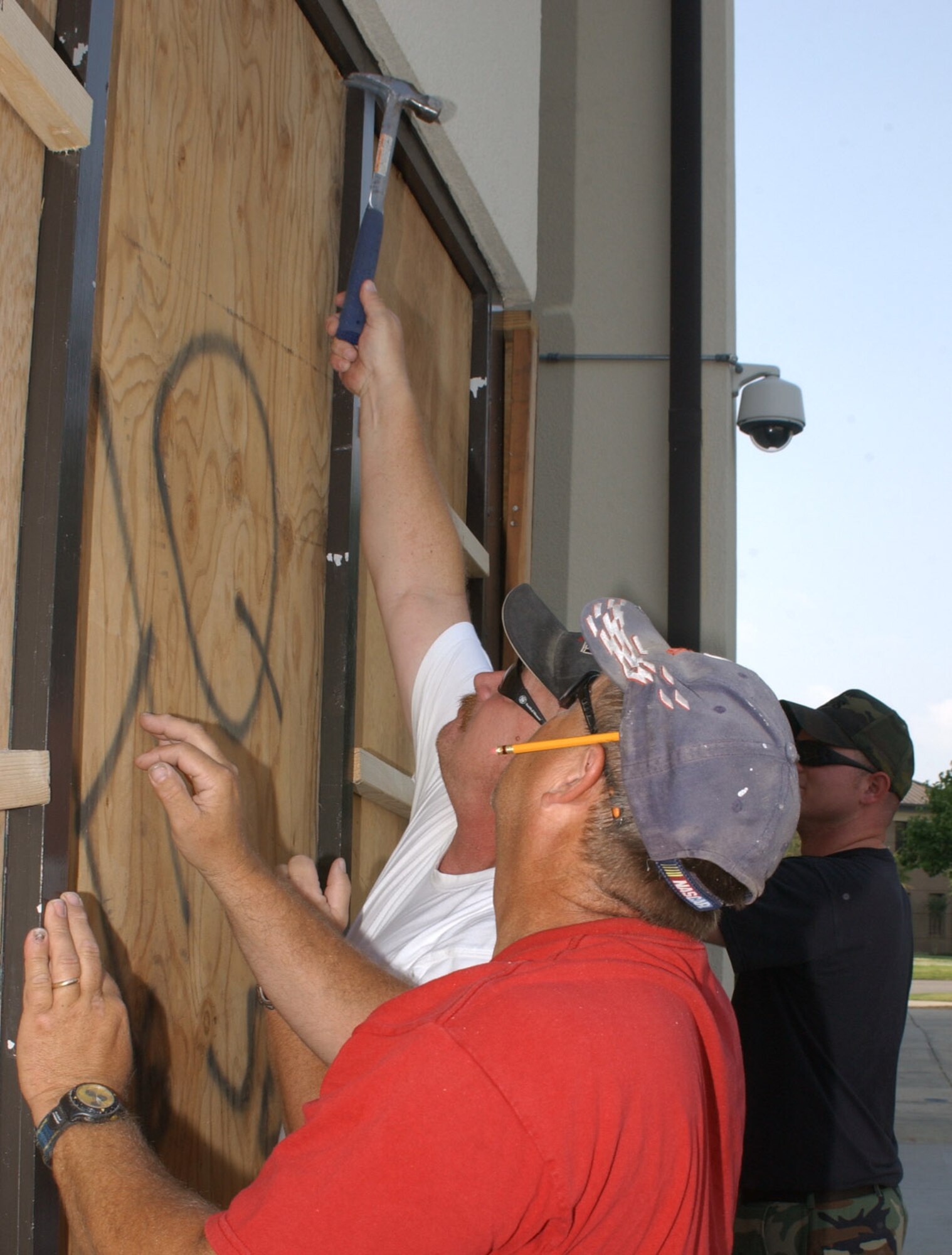 From left, John Dunn, Greg Wilson and Senior Airman Trevor Connelly, 81st Civil Engineer Squadron, board up an entrance to Wolfe Hall as “Hurricane Michael” approaches the base May 3.