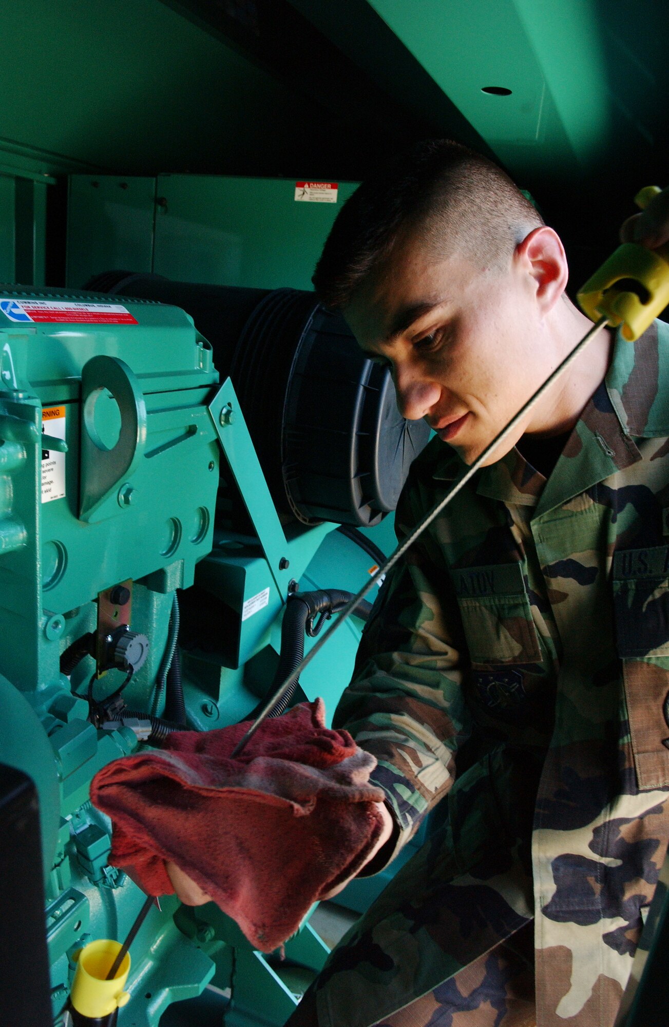 Staff Sgt. Cahramon Pulatov checks the oil level on a generator during a pre-operational maintanence inspection at Vandenberg AFB May 7.  The power production journeyman with the 30th Civil Engineer Squadron maintains the machines like this one that generate auxiliary power and helps to ensure lighting for the Vandenberg flight line during a commercial power outage. (U.S. Air Force photo by Staff Sgt. DeNoris Mickle)