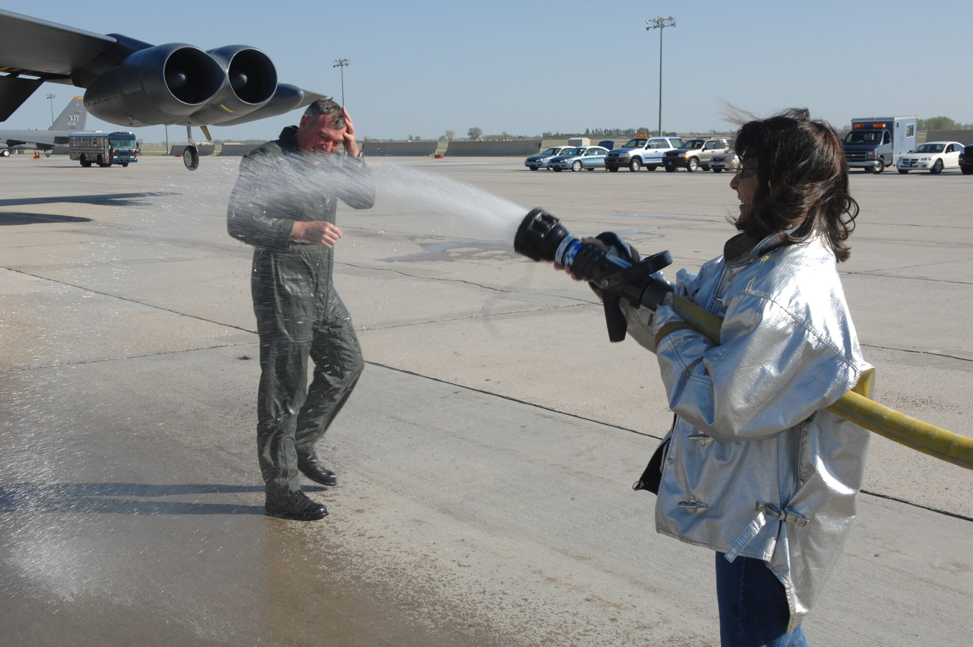 MINOT AIR FORCE BASE, N.D. – Col. Eldon Woodie, 5th Bomb Wing commander, gets hosed down by his wife, Bonnie, after his final flight as an Air Force pilot May 7. Upon completion of a crew member’s 'fini-flight,' it is Air Force tradition to be drenched with water upon landing by family members and fellow Airmen before being toasted with champagne. A command pilot with more than 4,700 hours, Colonel Woodie retires from the Air Force in June after 26 years of service. (U.S. Air Force photo by Senior Airman Christopher Boitz)