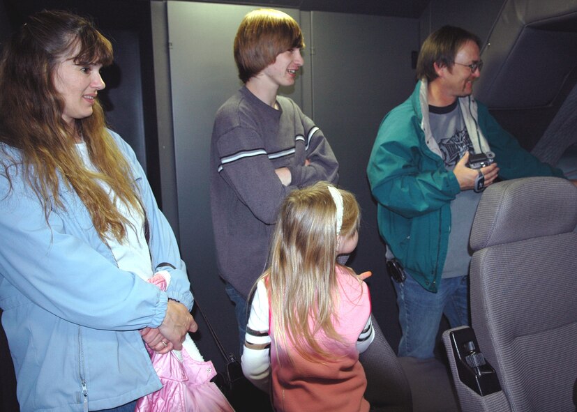 FAIRCHILD AIR FORCE BASE, Wash. -- Dylan Nickerson’s mother, Merri; brother  Cody, 17; sister, Shayna, 6; and father, Bruce, watch as Dylan maneuvers the simulated aircraft over a variety of destinations during one of the 509th Weapon Squadron“Pilot for a Day” events. (U.S. Air Force photo/Airman 1st Class Kali L. Gradishar)