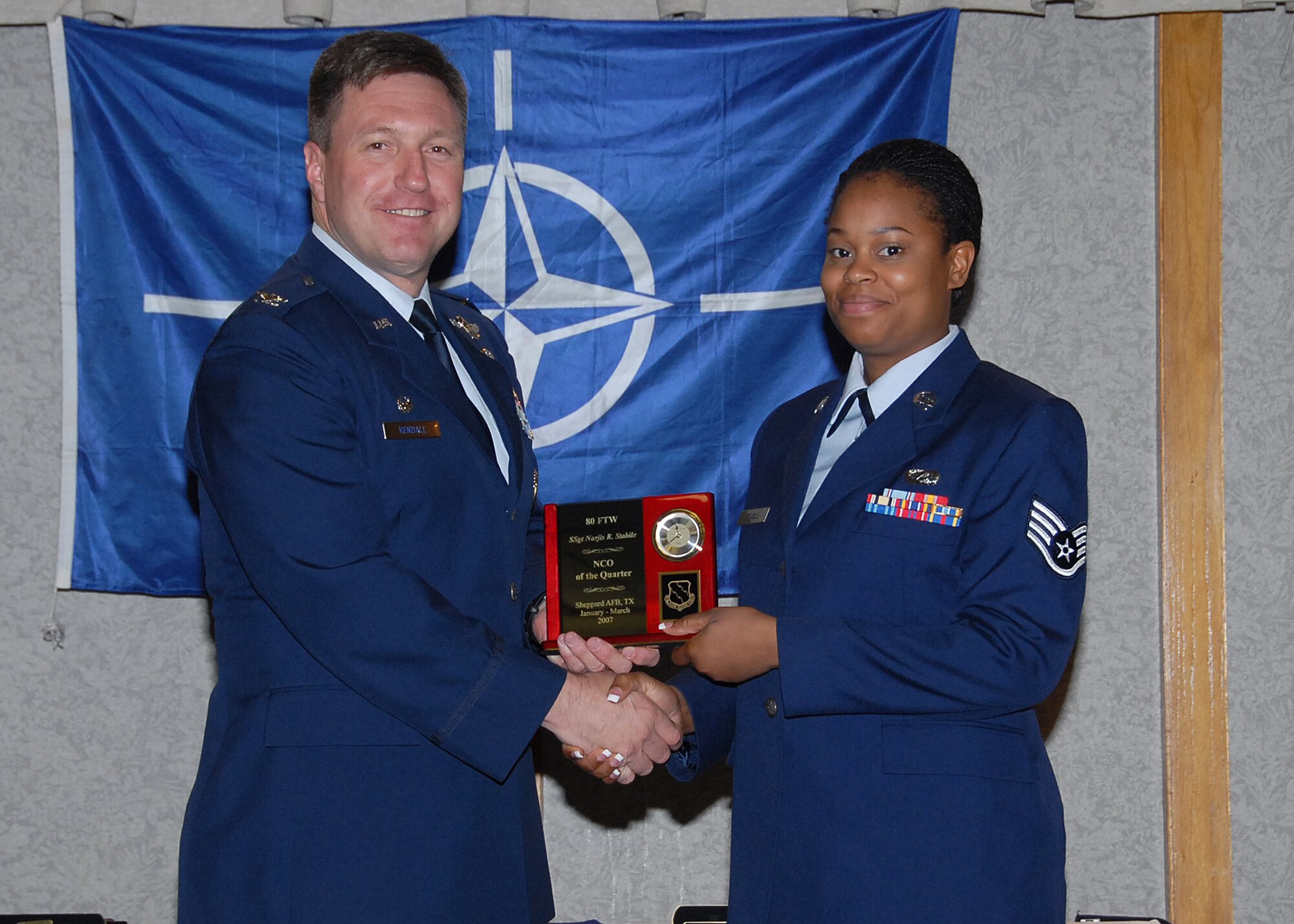 Col. Jeffrey Kendall, 80th Flying Training Wing Commander, presents Staff Sgt. Narjis Stabile, 80th FTW, with the award for noncommsioned officer of the quarter at the 80th FTW quarterly awards luncheon. (U.S. Air Force photo)