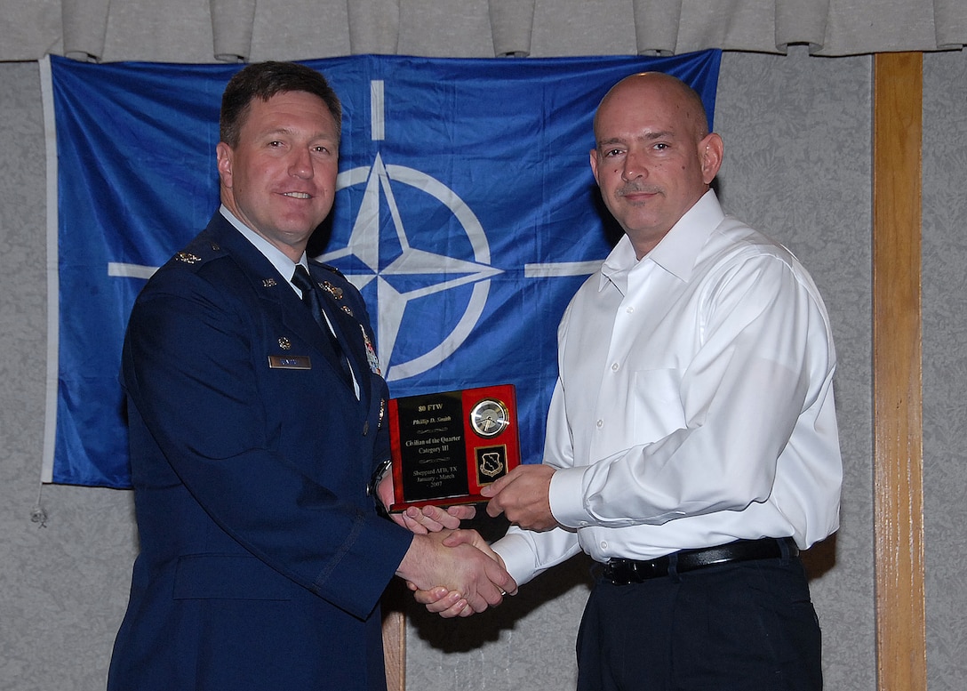Col. Jeffrey Kendall, 80th Flying Training Wing Commander, presents Mr. Phillip Smith, 80th Operations Support Squadron, with the award for civilian of the quarter, category three, at the 80th FTW quarterly awards luncheon. (U.S. Air Force photo)