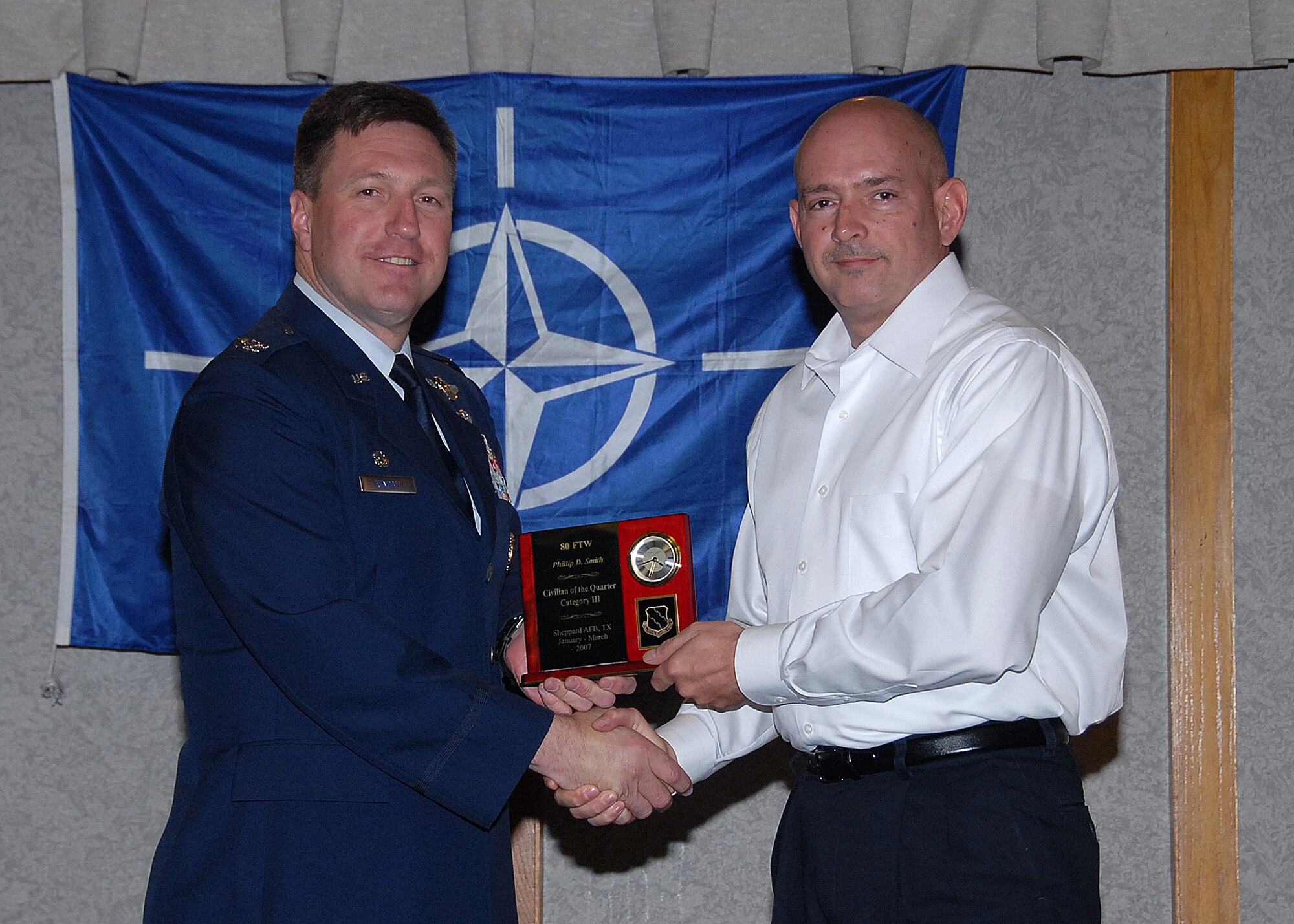Col. Jeffrey Kendall, 80th Flying Training Wing Commander, presents Mr. Phillip Smith, 80th Operations Support Squadron, with the award for civilian of the quarter, category three, at the 80th FTW quarterly awards luncheon. (U.S. Air Force photo)