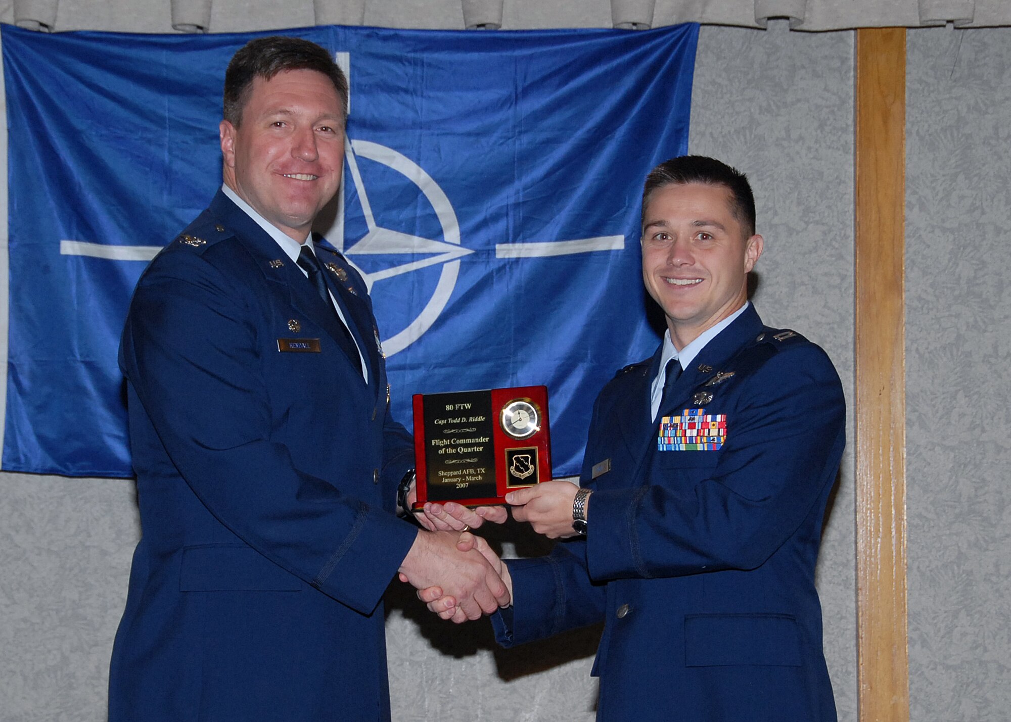 Col. Jeffrey Kendall, 80th Flying Training Wing Commander, presents Capt. Todd Riddle, 90th Flying Training Squadron, with the award for flight commander of the quarter at the 80th FTW quarterly awards luncheon. (U.S. Air Force photo)