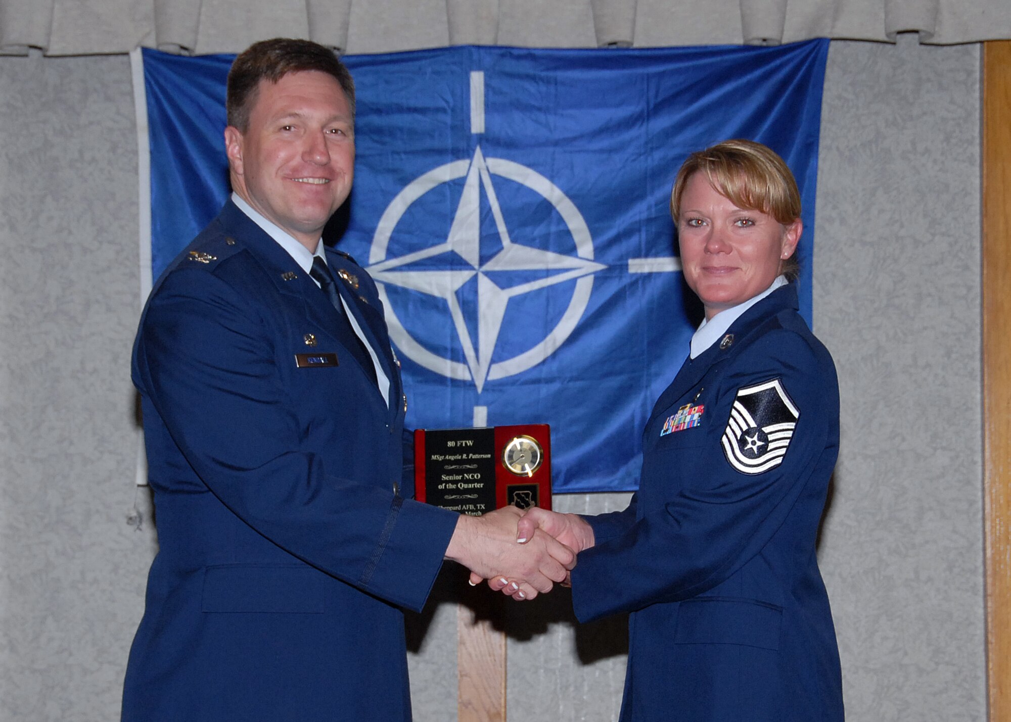 Col. Jeffrey Kendall, 80th Flying Training Wing Commander, presents Master Sgt. Angie Patterson, 80th Operations Support Squadron, with the award for senior noncommsioned officer of the quarter at the 80th FTW quarterly awards luncheon. (U.S. Air Force photo)
