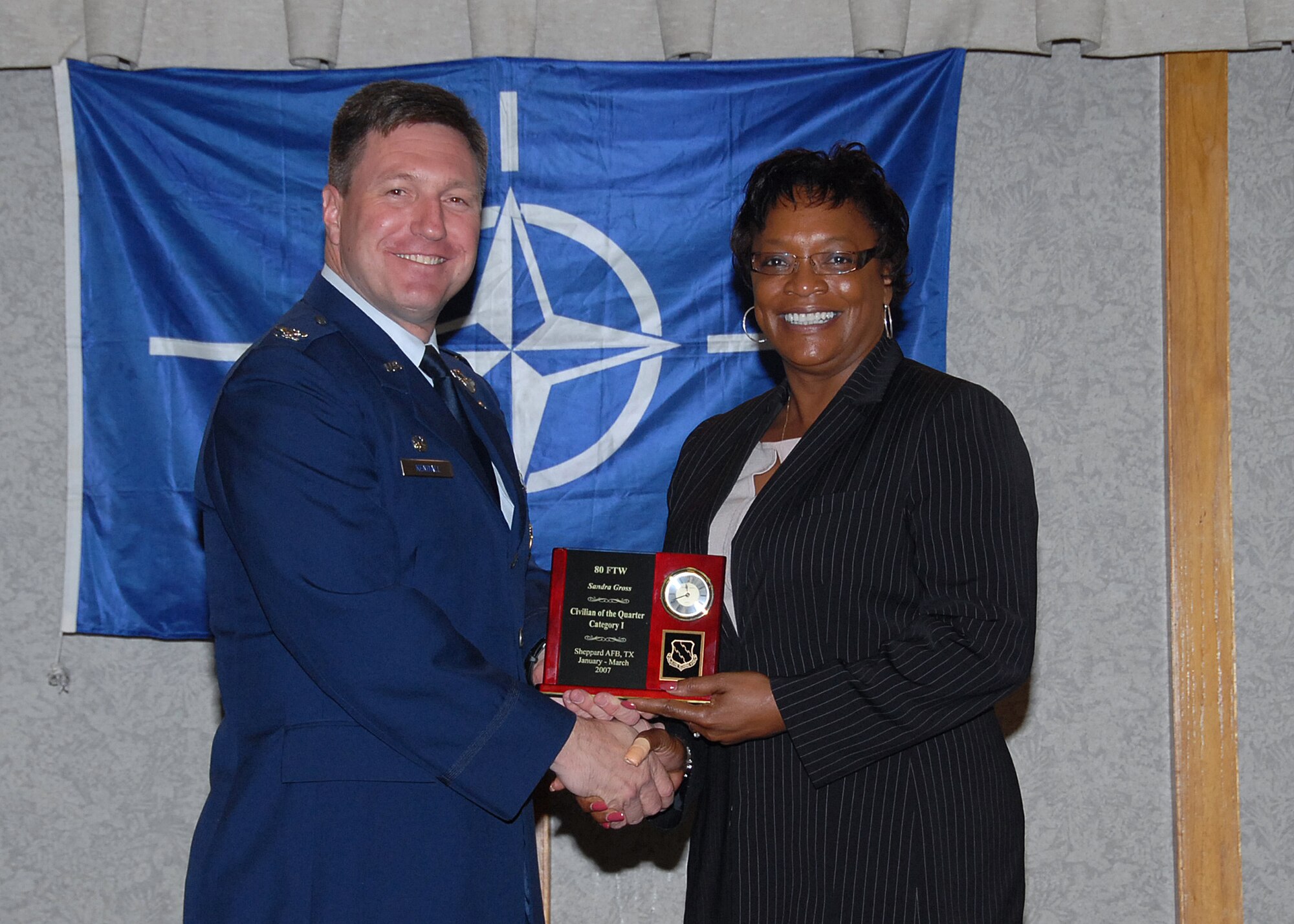 Col. Jeffrey Kendall, 80th Flying Training Wing Commander, presents Ms. Sandra Gross, 89th Flying Training Squadron, with the award for civilian of the quarter, category one, at the 80th FTW quarterly awards luncheon. (U.S. Air Force photo)