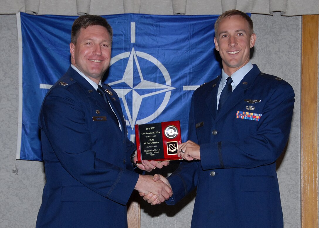 Col. Jeffrey Kendall, 80th Flying Training Wing Commander, presents Capt. Jonathan Elza, 90th Flying Training Squadron, with the award for company grade officer of the quarter at the 80th FTW quarterly awards luncheon. (U.S. Air Force photo)