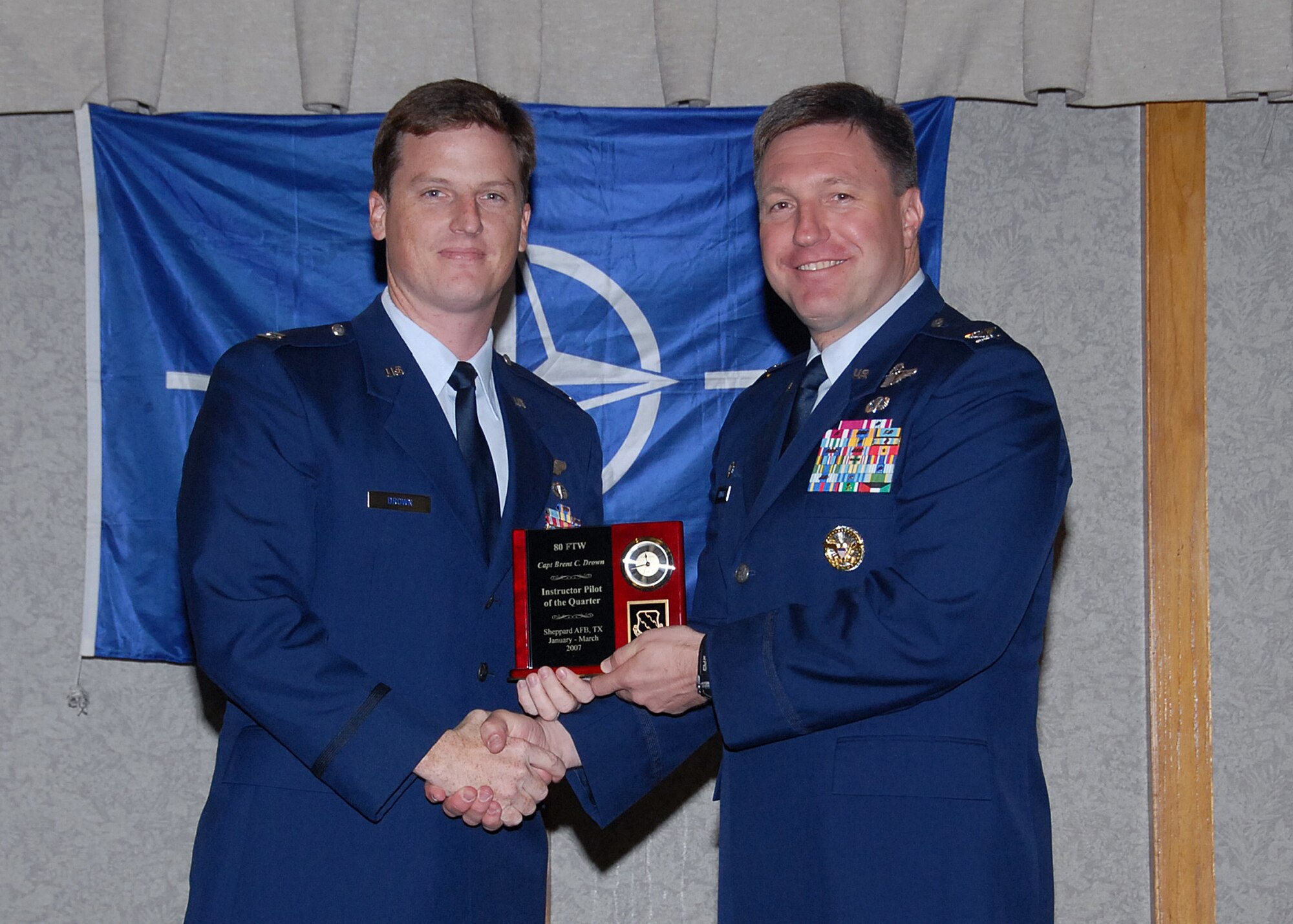 Col. Jeffrey Kendall, 80th Flying Training Wing Commander, presents Capt. Brent Drown, 88th Flying Training Squadron, with the award for instructor pilot of the quarter at the 80th FTW quarterly awards luncheon. (U.S. Air Force photo)