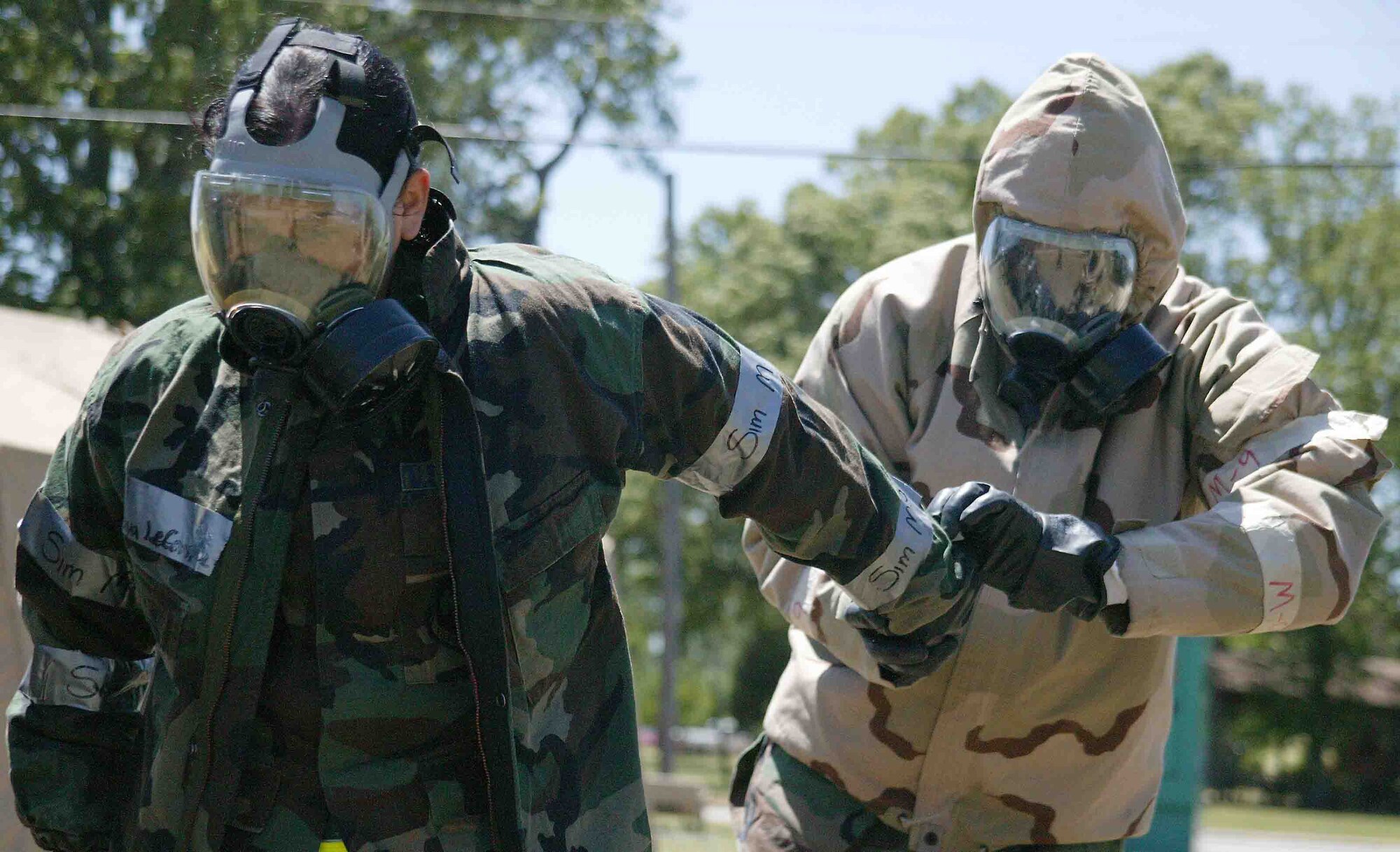 SHAW AIR FORCE BASE, S.C. -- Master Sgt. Vernon Turnbull (right), 20th Maintenance Operations Squadron, removes chemical warfare gear from Senior Airman Sonya Lecompte, 20th Component Maintenance Squadron, at a decontamination processing line May 7 during the Phase II exercise. Phase II exercises evaluate Airmen's ability to operate and survive in deployed locations. (U.S. Air Force photo/Senior Airman John Gordinier)
