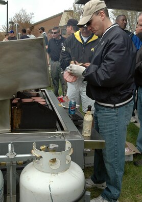 FAIRCHILD AIR FORCE BASE, Wash. -- Fairchild first sergeants throw beef patties on the grill during the dorm barbecue May 4. The barbecue was provided by Fairchild first sergeants and was open to the dormitory residents wanting food and fun. (U.S. Air Force photo/Airman 1st Class Kali L. Gradishar)