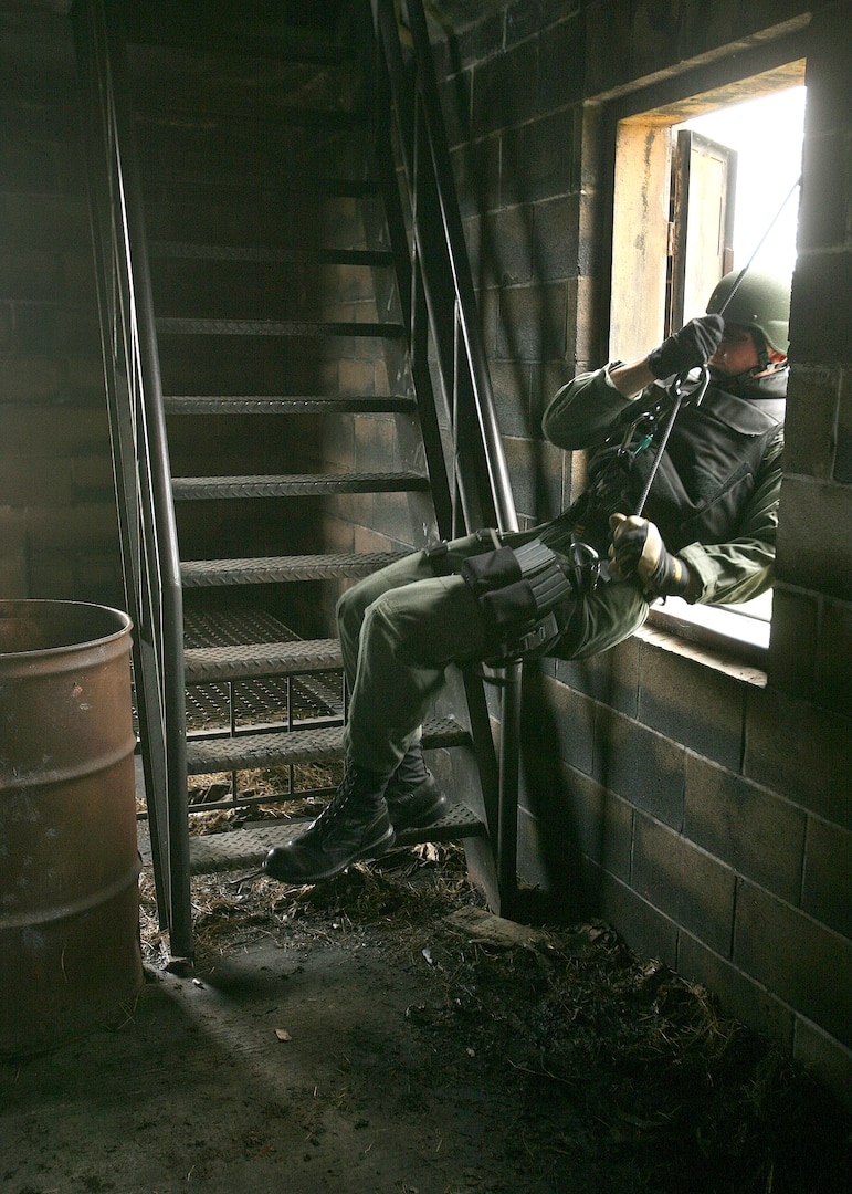 After repelling off the outer wall, 1st Lt. Stephen Addington swings through the open window of a target building during Emergency Services Team training May 4 at Lackland Air Force Base, Texas. Lieutenant Addington was on the team that competed at the Southeast Texas SWAT Competition April 24 in Beaumont, Texas. The Lackland AFB team placed first in the competition. (U.S. Air Force photo/Robbin Cresswell)
