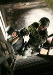 Staff Sgt. Bryan Garcia (left) and Master Sgt. Ronald Thompson cover each other as they make their way up a flight of stairs to the attic to clear a target building during a training session May 4 at Lackland Air Force Base, Texas. Sergeants Garcia and Thompson are members of the 37th Training Wing's Emergency Services Team at Lackland AFB, who competed in the Southeast Texas SWAT competition April 24 and took a first. (U.S. Air Force photo/Robbin Cresswell)
