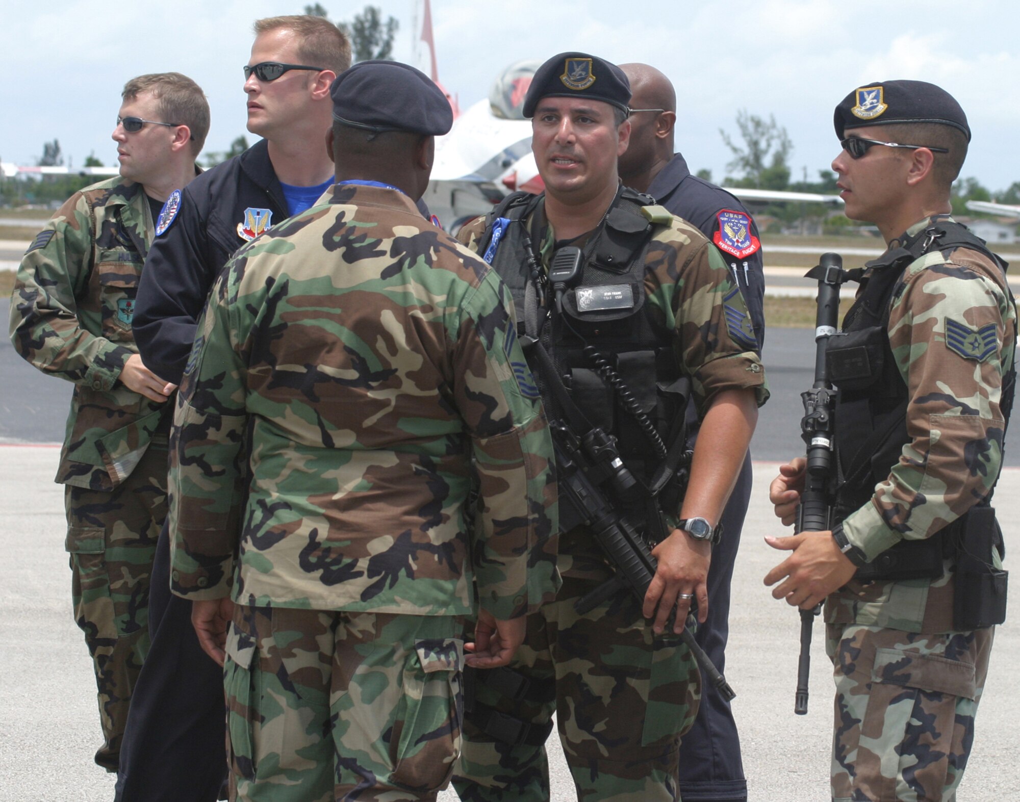 Master Sgt. John Frank (center) talks with Staff Sgt. Moises Ostolaza and other security forces members from Air Force Reserve Command’s 482nd Fighter Wing on the ramp of the Opa Locka airport during the 2007 McDonald’s Air and Sea Show in Ft. Lauderdale, Fla.  The reservists provided security for all visiting aircraft during the four-day event which attracted more than two million visitors.  Also shown in the background members of the F-22 Raptor ground crew make sure security concerns are taken care of.  (U.S. Air Force photo/Tech. Sgt. Paul Dean)