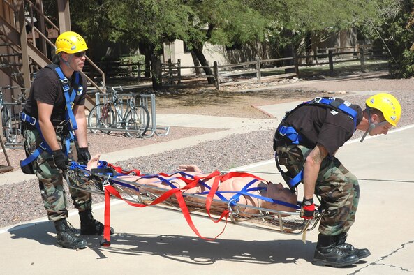 Staff Sgt. Michael Long (left) and Airman 1st Class Jason Abbey, both firefighters at D-M, lower a dummy victim onto the "helipad" after a simulated canyon rescue here April 30. The specialized rescue training was part of a three-week course taught by three instructors from the United States Air Forces in Europe Fire Academy, who traveled here and certified 19 D-M firefighters. (U.S. Air Force photo/Staff Sgt. Jake Richmond)