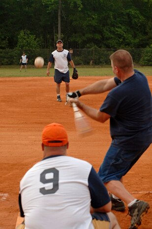 Phil Wilson, Boeing Repair and Modification Services, swings at the ball pitched by Jamie Chapman, 1st Combat Camera Squadron, here Tuesday evening.  (U.S. Air Force photo/ Staff Sgt. April Quintanilla)