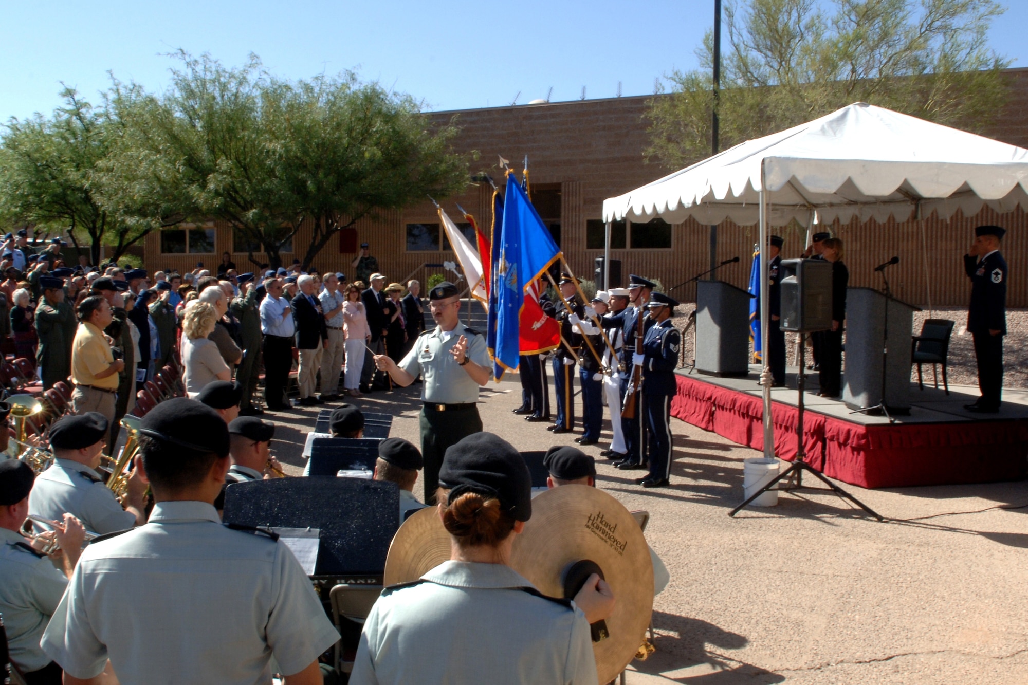 More than 200 military and civilians salute the U.S. flag as the national anthem is played by the 36th Army Band, May 9, during a ribbon cutting ceremony held for the unveiling of the new James H. Doolittle Combined Air and Space Operations Center at Davis-Monthan Air Force. The building was named in honor of General James H. Doolittle, 12th Air Force’s first commander and the Doolittle Raiders for their heroic actions during World War II.  Photo by Tech. Sgt. Kerry Jackson
