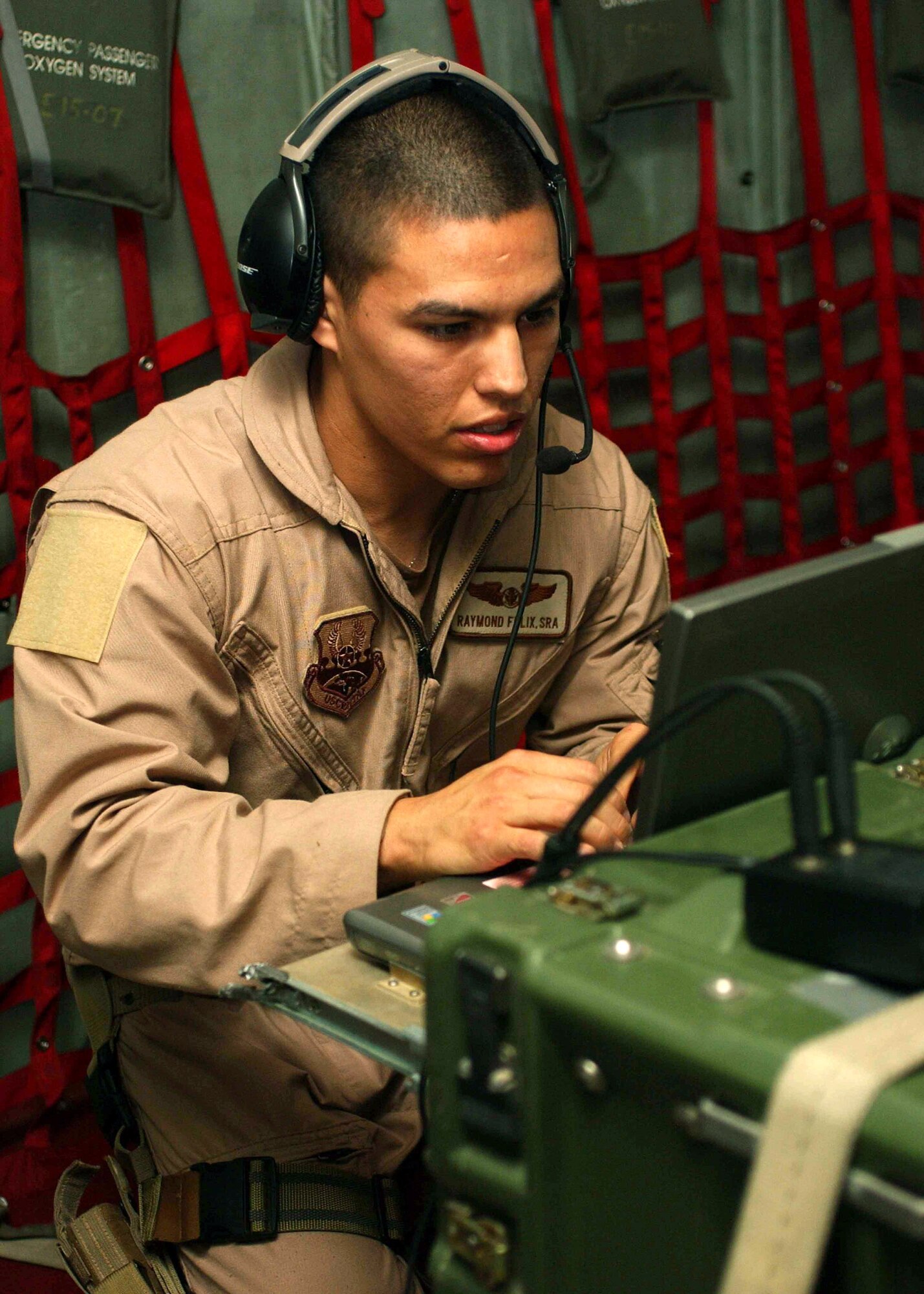 Senior Airman Raymond Felix checks over his communications gear before taking off on a Joint Airborne Battle Staff mission over Iraq.  While they fly, joint service battle staff members monitor several radio channels at a time, listening in on coalition convoys on the ground and relaying radio calls when necessary, ranging from routine radio checks to medical evacuation requests.  Airman Felix is a communications technician with the battle staff.  (U.S. Army photo/Army Sgt. Alexandra Hemmerly-Brown)