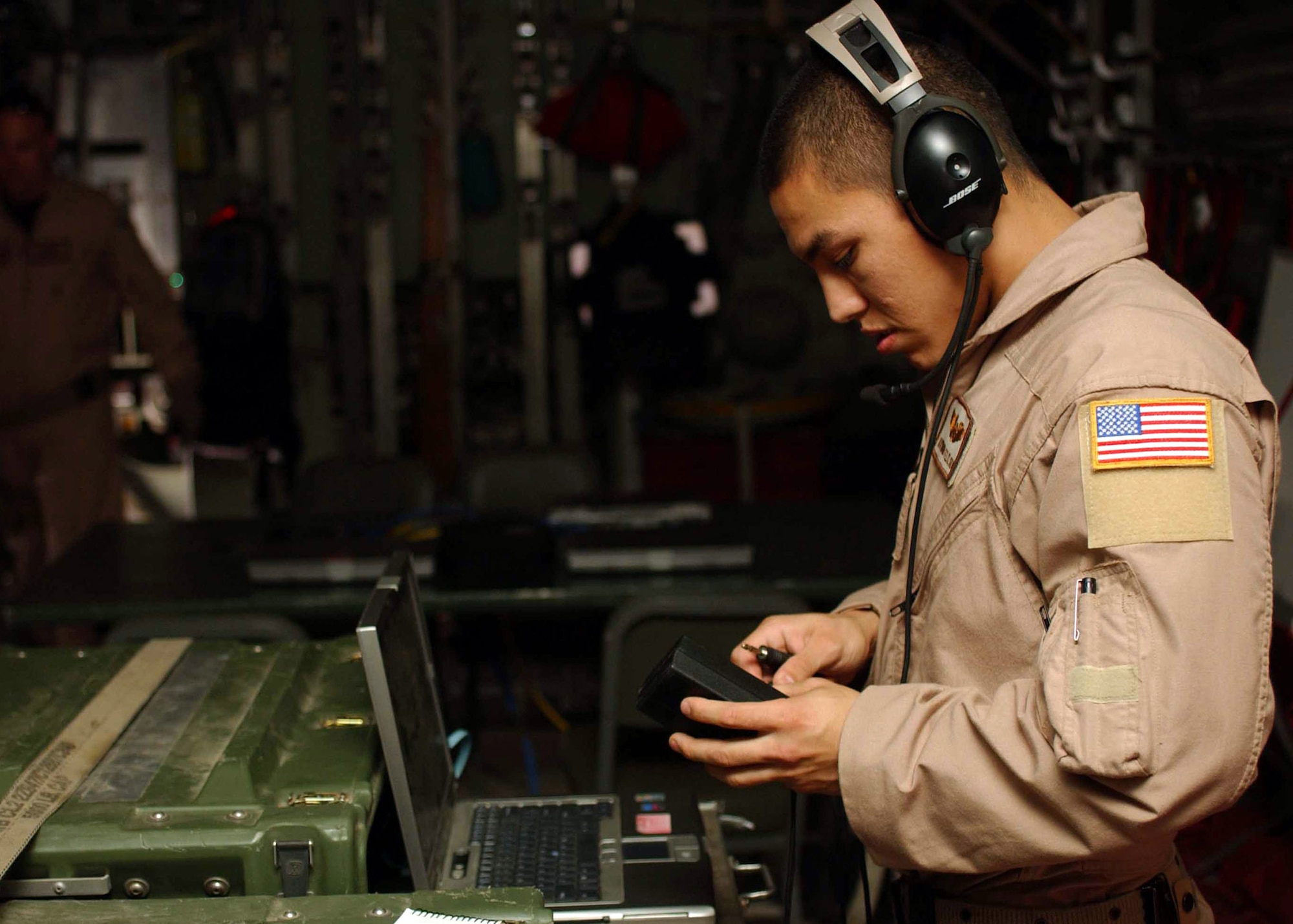 Senior Airman Raymond Felix checks over his communications gear before taking off on a Joint Airborne Battle Staff mission over Iraq.  While they fly, joint service battle staff members monitor several radio channels at a time, listening in on coalition convoys on the ground and relaying radio calls when necessary, ranging from routine radio checks to medical evacuation requests.  Airman Felix is a communications technician with the battle staff.  (U.S. Army photo/Army Sgt. Alexandra Hemmerly-Brown)