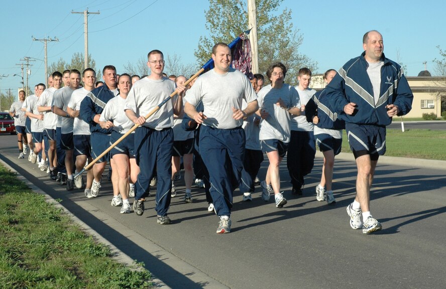 MINOT AIR FORCE BASE, N.D. -- Members of the 5th Communications Squadron, led by the commander, Lt. Col. Rob Schutt (far right), run down Peacekeeper Place here May 9. The 5th CS performs squadron physical training Mondays, Wednesdays and Fridays. Air Force standards require all Airmen be fit to fight. (U.S. Air Force photo by Airman 1st Class Wesley Wright)