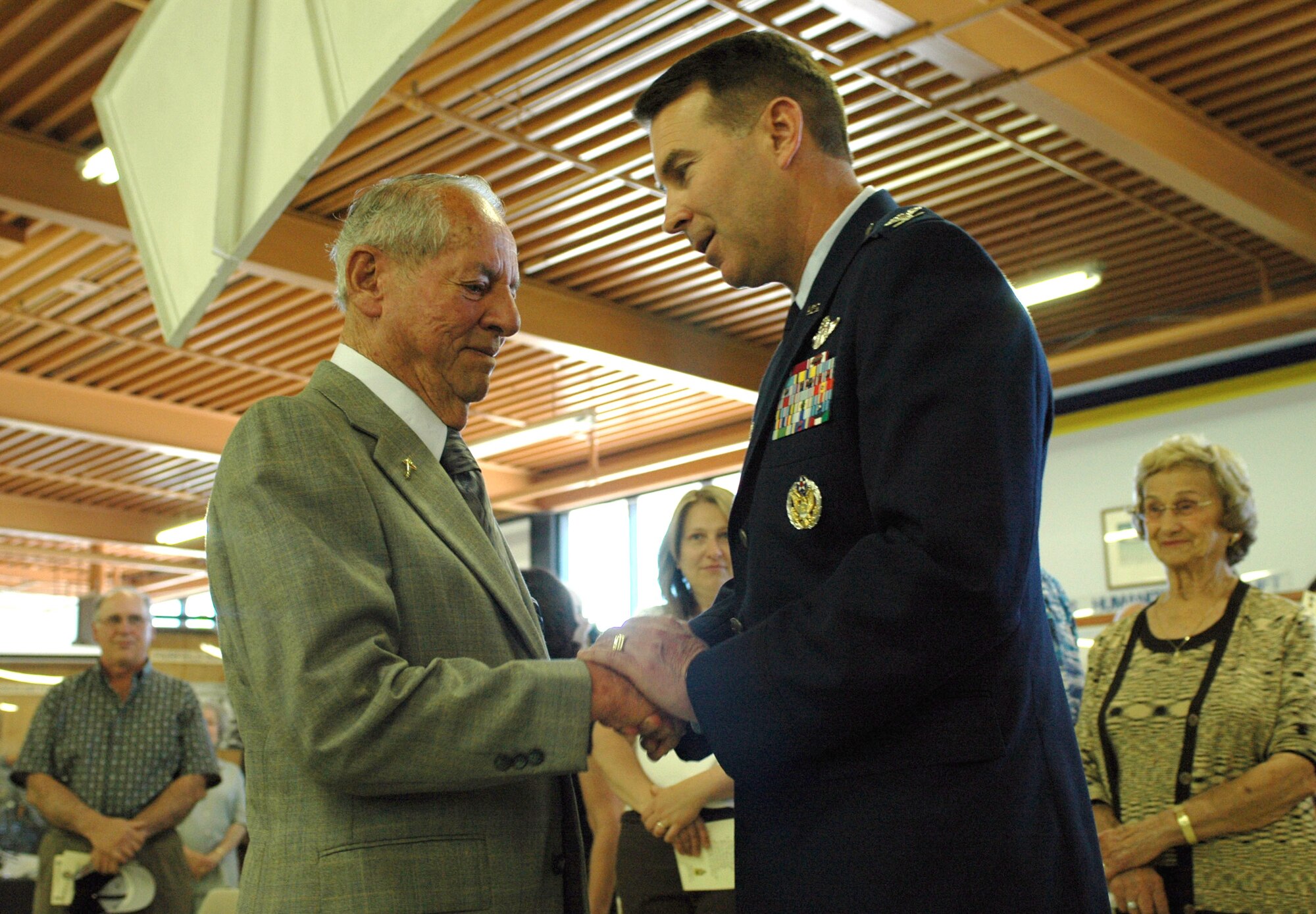 Art Cader, a former Army Air Corps first lieutenant, is congratulated by Col. Steve Arquiette after receiving the Distinguished Flying Cross during a ceremony May 7 at Travis Air Force Base, Calif. Mr. Cater was presented the medal for his heroism as a pilot during World War II. Colonel Arquiette is the 60th Air Mobility Wing commander. (U.S. Air Force photo/Airman Kristen Rohrer)