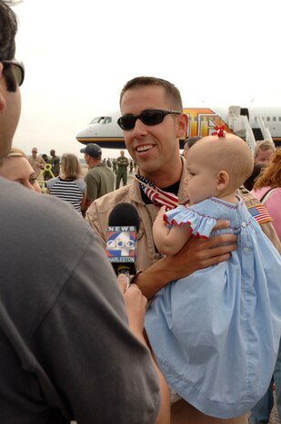 Capt. Nathan Phillips 15th Airlift Squadron, is interviewed by a local news crew after arriving home from a four month deployment to Southwest Asia, May 5.  (U.S. Air Force photo/Staff Sgt. April Quintanilla)