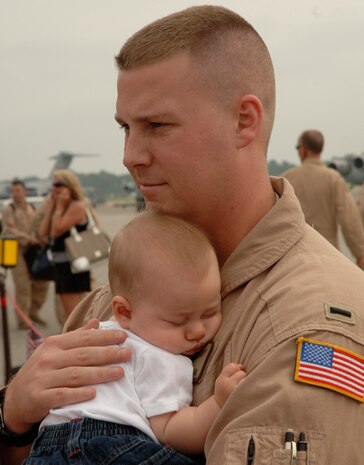 After being deployed for 140 days, 1st Lt. John Shaffer returns home and cradles his four month old son. (U.S. Air Force photo/ Staff Sgt. April Quintanilla)