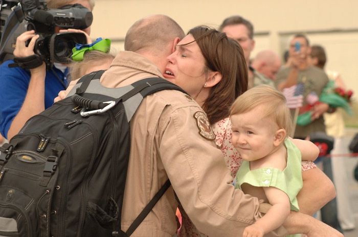 Maj. Kyle Benwitz, 15th Airlift Squadron, embraces his wife, Michelle, and his two daughters after returning from Southwest Asia after his squadron's four month deployment.  (U.S. Air Force photo/Staff Sgt. April Quintanilla)