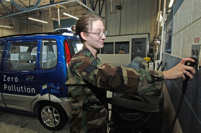 Airman 1st Class Heather Coffman, 437th Logistics Readiness Squadron, recharges the base's new Miles ZX40 all-electric, zero pollution, low speed vehicle May 7.  (U.S. Air Force photo/Staff Sgt. April Quintanilla) 