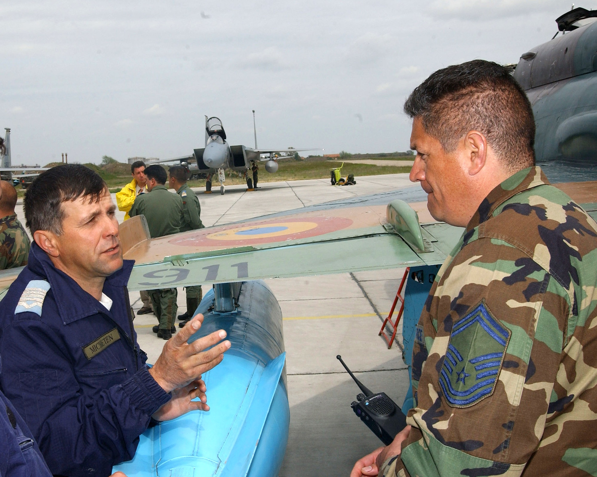 Romanian Air Force Warrant Officer Marian Micheten (left) discusses the maintenance side of MiG-21 operations with Senior Master Sgt. Santos Rodriguez during Exercise Sniper Lance May 1 at Mihail Kogalniceanu Air Base, Romania. The exercise is the first since U.S. and Romanian officials signed a Presence Agreement, which allowed for the presence of U.S. forces at Romanian bases beginning in 2007. Warrant Officer Micheten is a technician with the 862nd Squadron. Sergeant Rodriguez is the 493rd Aircraft Maintenance Unit lead production superintendent. (U.S. Air Force photo/Master Sgt. Charles Tubbs) 