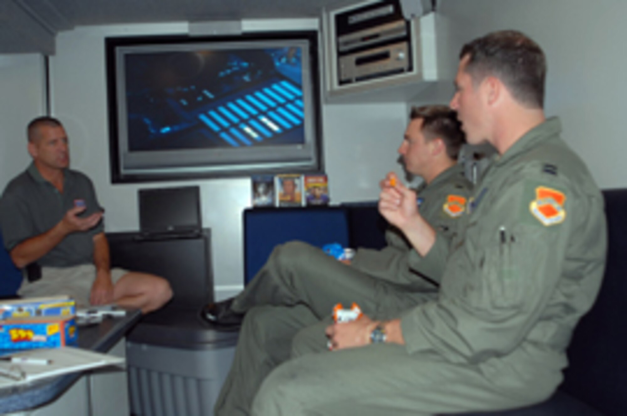 Corey Hulse, United Service Organizations western region logistics and maintenance manager, explains to Capt. Jonathan Leatherwood and 1st Lt. Evan Schonour, 309th Fighter Squadron pilots, the importance of a mobile USO center and the effect it has on Airmen moral. Designed to be a USO center on wheels, these vehicles provide signature USO services to military members where traditional “brick and mortar” facilities do not exist. Their ability to move about the country allows communities and organizations the opportunity to come together at events and show their support for our men and women in uniform. (Photo by Staff Sgt. Phillip Butterfield)
