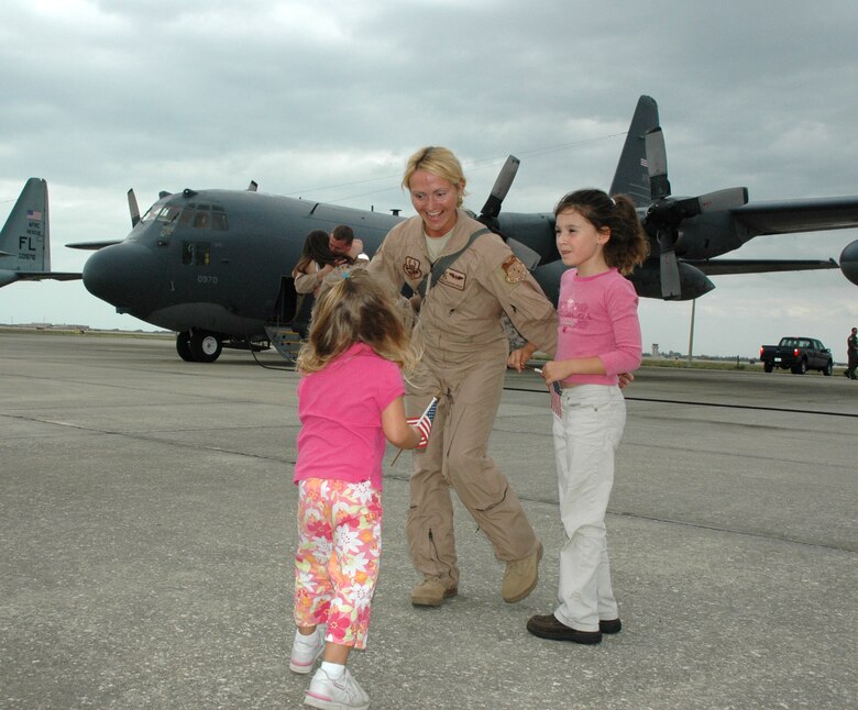 Air Force Reservist, SrA Jennifer Drake, 920th Rescue Wing HC-130 radio operator, readies a group hug for two young patriots who eagerly wait her return from a two-month deployment to Joint Task Force - Horn of Africa.  Airmen from the 920th Rescue Wing have been providing ongoing combat search and rescue to the African region.  (u.S. Air Force photo/Capt. Cathleen Snow)