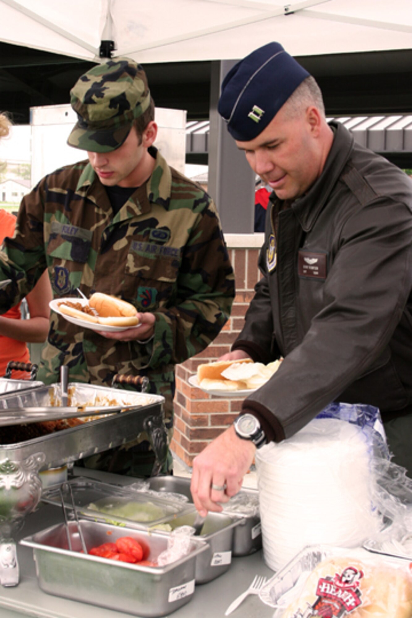 GRISSOM AIR RESERVE BASE, Ind. -- Capt. Brian Thompson, right, a KC-135R Stratotanker pilot with the 72nd Air Refueling Squadron, and Senior Airman Jerod Foley, a financial management apprentice with the 434th Air Refueling Wing, enjoy an outdoor lunch in conjunction with the Outdoor Recreation Equipment Rental open house hosted by the 434th Services Flight. This event provided an insight into the variety of new and well kept equipment available for recreational rental at Grissom Air Reserve Base. (U.S. Air Force photo/Senior Airman Omar Delacruz)