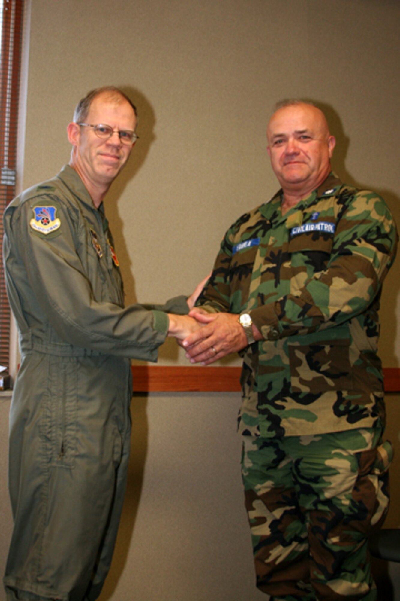 GRISSOM AIR RESERVE BASE, Ind. -- Col. Kerry Keithcart, the 434th ARW vice commander (left), welcomes and presents a vice commander challenge coin to Chaplain (Lt. Col.) Larry Franklin, the Deputy Region Chaplain for the Great Lakes Region Civil Air Patrol, during the Annual Chaplain Staff College at Grissom Air Reserve Base. The chaplain college provides instruction to Civil Air Patrol chaplains in subject matters ranging from military customs and courtesies to radio equipment usage. The Great Lakes Civil Air Patrol Chaplain Service located at Grissom conducts, what is considered, one of the best Civil Air Patrol staff colleges in the Nation.(U.S. Air Force photo/Senior Airman Omar Delacruz)