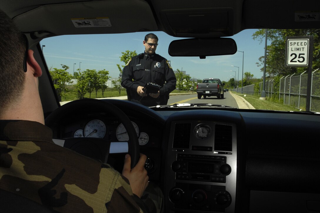 Department of Defense Police Officer Richard Twitchell checks the liscene plate number before issuing a  speeding ticket on Bolling May 8. The 101 critical days of summer are aproaching and speeding is one of the leading causes of accidents every year. (U.S. Air Force Photo by Senior Airman Dan DeCook)