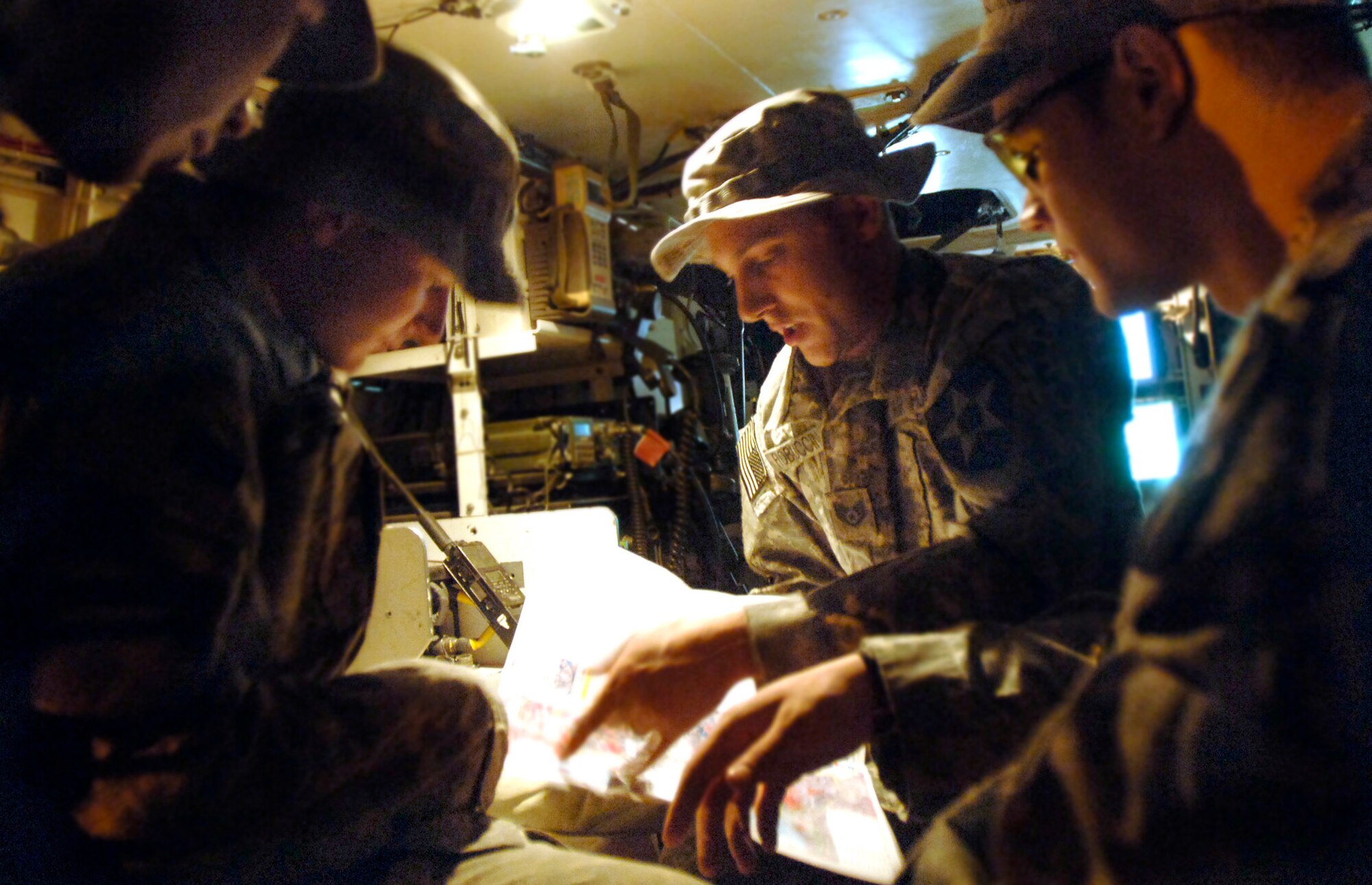During an early morning planning session in the back of a Stryker assault vehicle, Staff Sgt. Christopher Froboccino (center) shows his Soldier counterparts the route they will be traveling through Baghdad.  Sergeant Froboccino is a joint terminal attack controller in charge of communicating coordinates for close-air support during fire fights with enemy ground forces.  (U.S. Air Force photo/Tech. Sgt. Cecilio M. Ricardo Jr.)